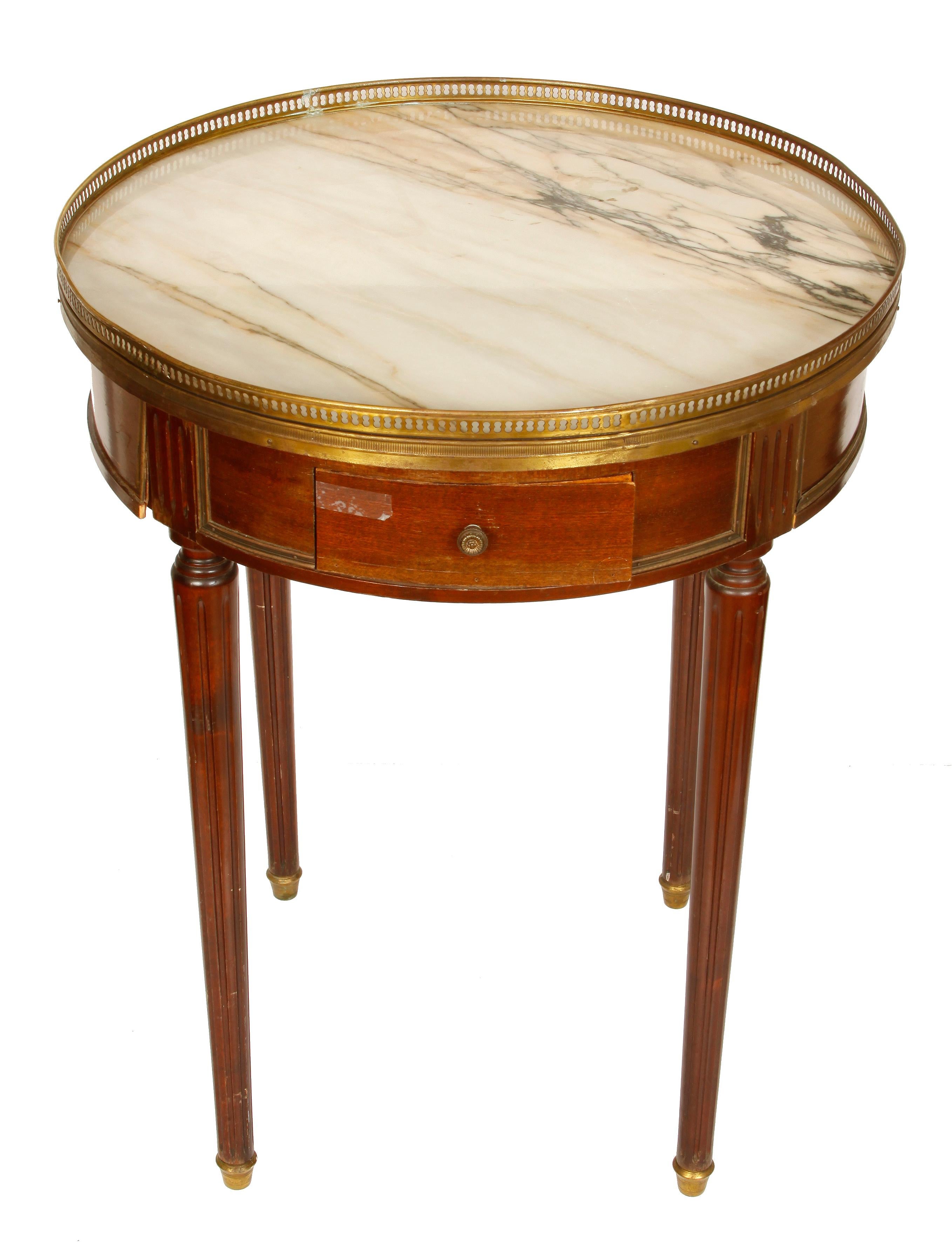 Louis XVI style bouillotte table with a pierced brass gallery encircling a marble top and brass caps on the feet.