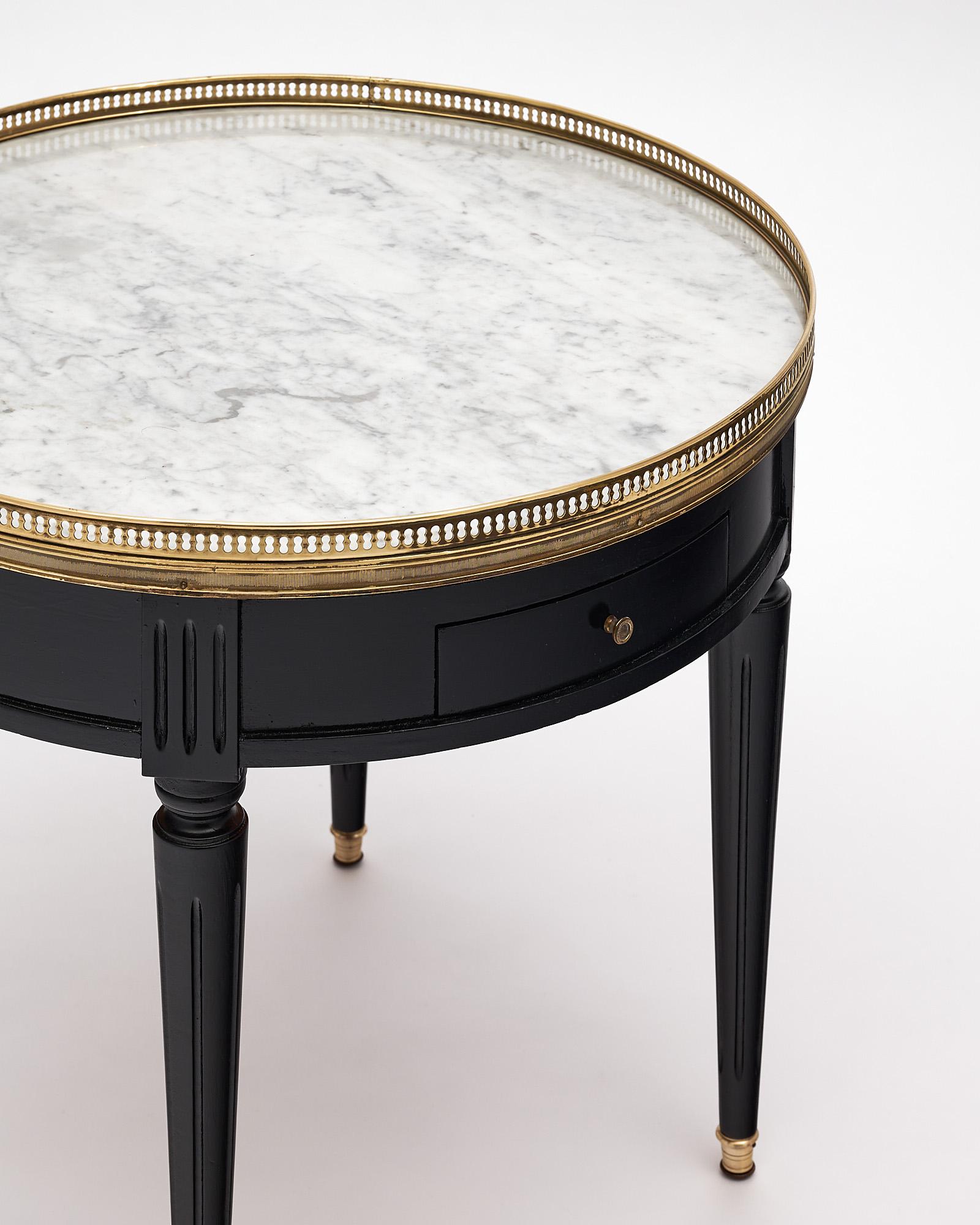 Side table, “bouillotte” Louis XVI style, made of ebonized Mahogany. White Carrara intact marble top is surrounded with an opened gilt brass gallery, the table features 2 pull out leaves covered with leather and two dovetailed drawers with brass