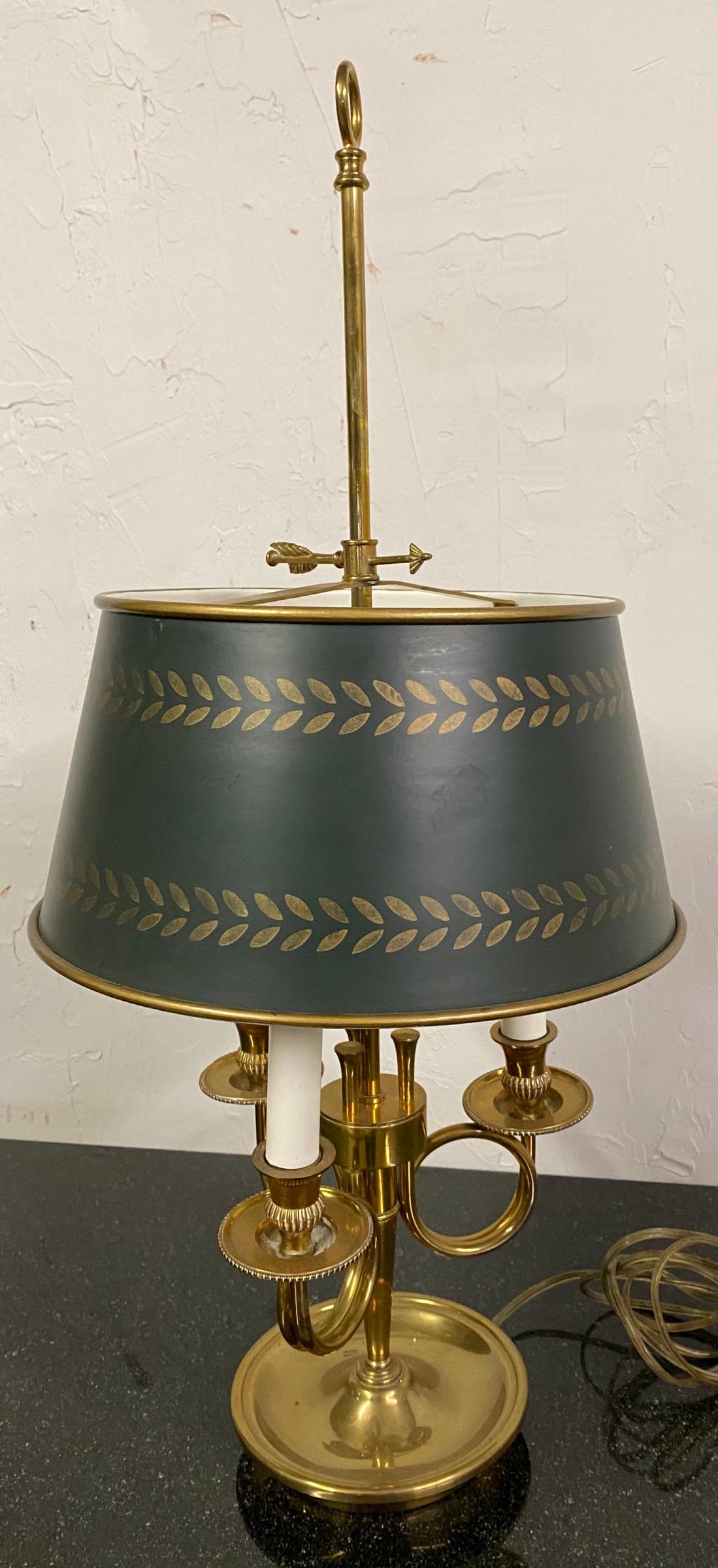This fine and elegant classic Louis XVI style brass and hand-painted tole bouillotte lamp has three-lights. The toleware shade is hand painted with green enamel and gold decoration. Lamp shade can be adjusted to different heights with the