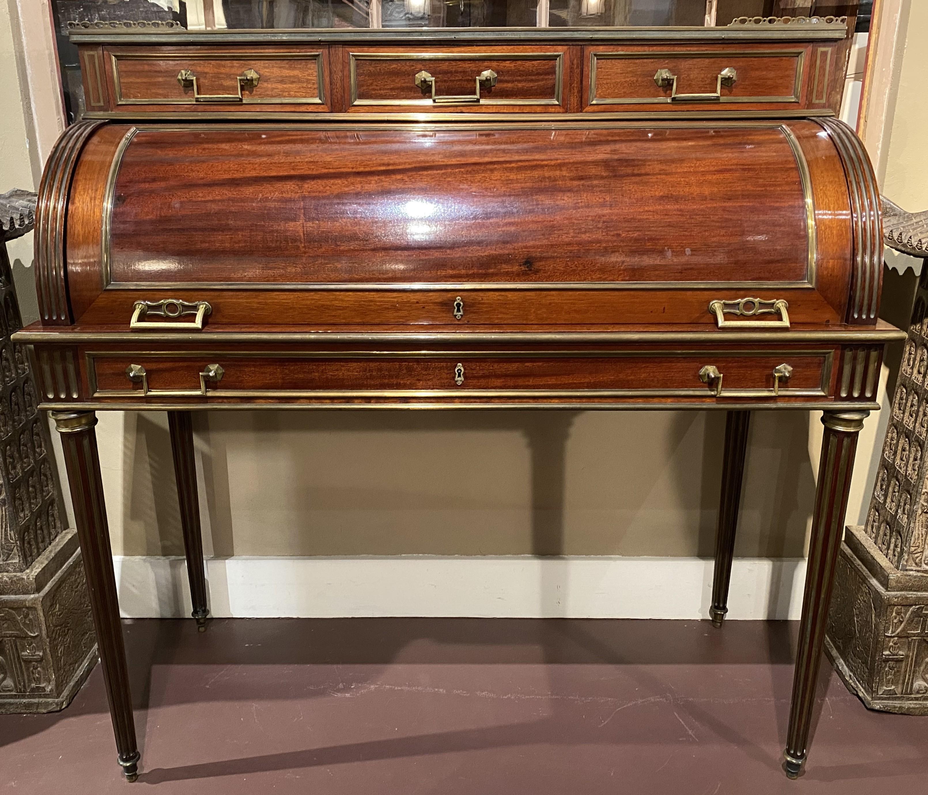 Splendida scrivania a cilindro in stile Luigi XVI in mogano con piano in marmo montato in ottone e galleria su tre cassetti montati che sormontano una cassa a cilindro con interni a scomparti, tra cui tre cassetti montati con scomparti aperti sopra