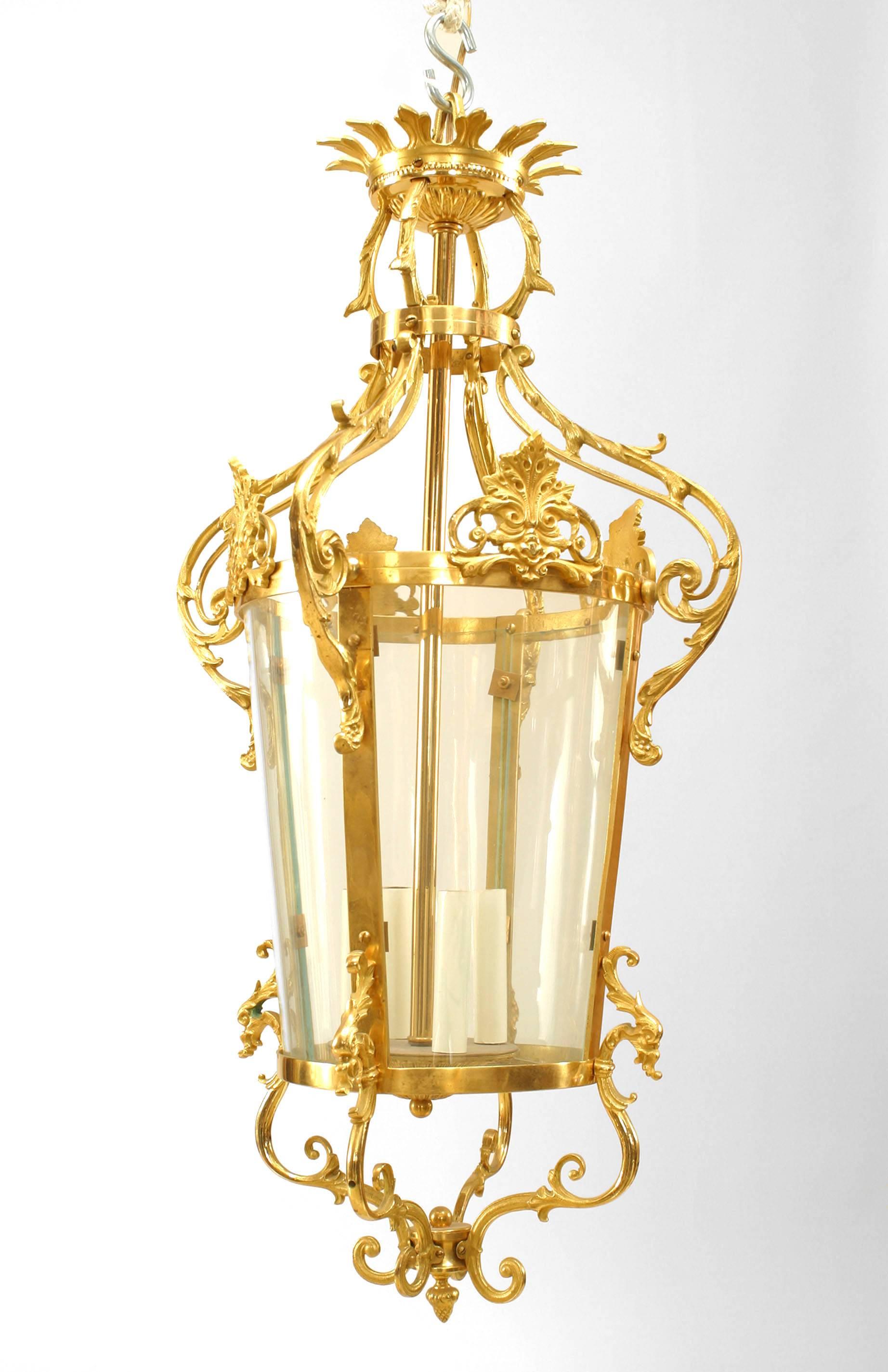 French Louis XVI style (20th Century) gilt bronze lantern with a 3 light center within 4 bent glass panels having scroll forms above and below with an acorn finial bottom.
