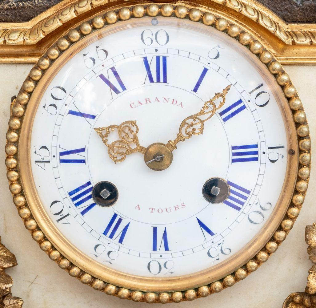 Pendule de style Louis XVI en bronze doré et patiné et marbre blanc, fin du XIXe siècle, le cadran circulaire en émail blanc avec mouvement à sonnerie signé 
