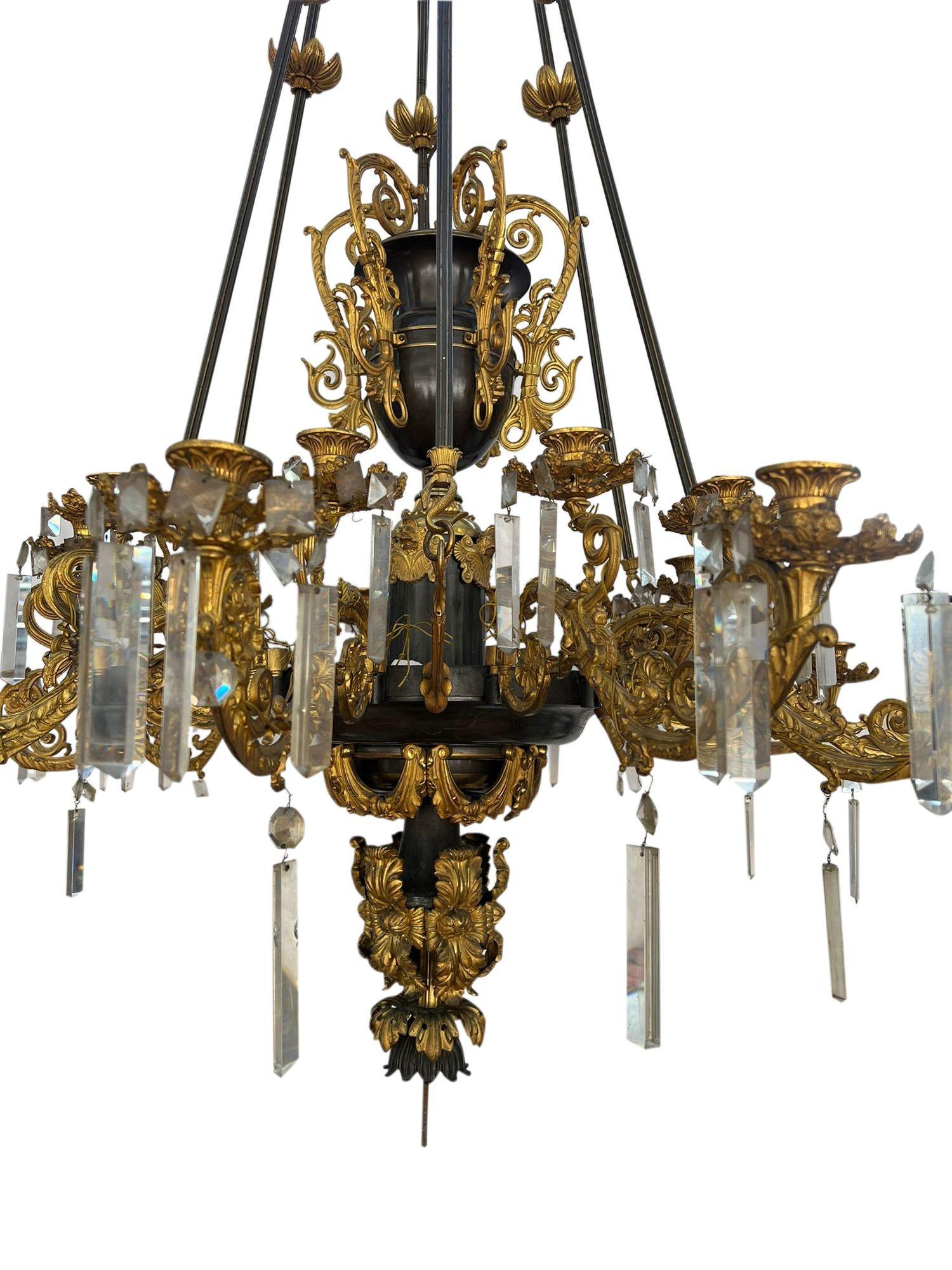 Un grand et impressionnant lustre de style Louis XVI en bronze et bronze doré à 12 branches, avec une urne centrale à 5 poignées, de merveilleuses branches feuillagées à enroulement avec des gouttes en verre taillé, une guirlande en bronze doré et