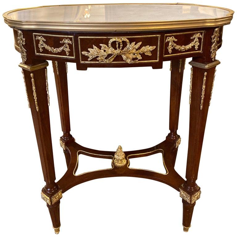 Zwei Tische im Louis-XVI-Stil mit Marmorplatte und Bronzebeschlägen, die mit Doré-Bronze umrahmt sind. Die Platte aus weißem Carrara-Marmor mit grauen Adern wird von einer Reihe von spitz zulaufenden, kannelierten Vierkantbeinen aus Bronze getragen,