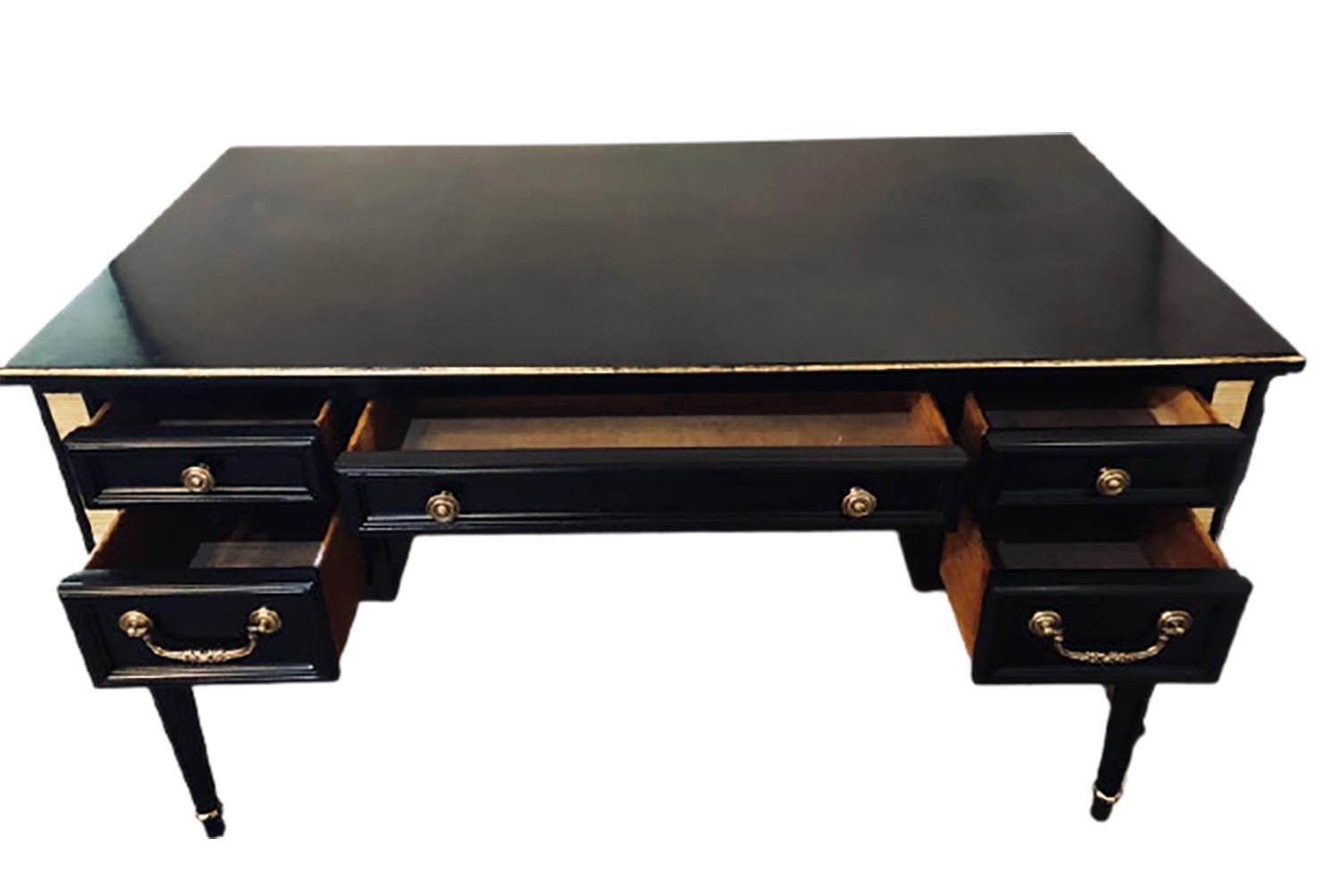 A Louis XVI style bronze-mounted ebony writing desk. This finely constructed writing desk has a large surface easily able to fit a working station and computer system. The center drawer flanked by a pair of side drawers with a large knee hole fitted