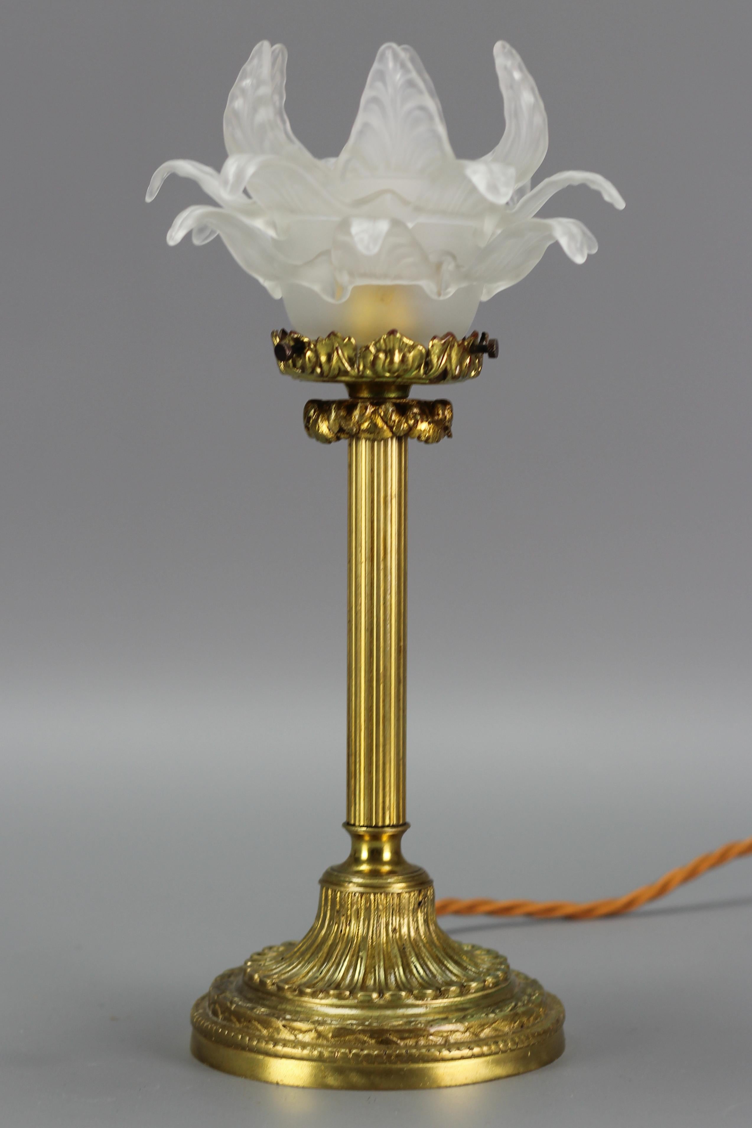 An adorable Louis XVI-style bronze table lamp with a frosted white glass lampshade in the shape of a flower, France, 1920s.
One socket for an E14-size light bulb. To the US will be shipped with an adapter for the US wiring system.
Dimensions: Height