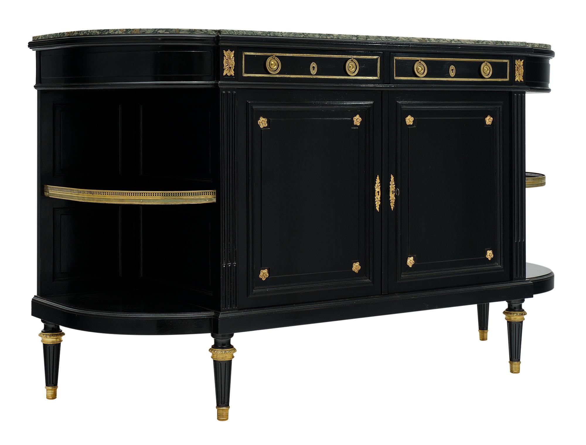Buffet / enfilade, French, made of ebonized mahogany and finished with a lustrous museum quality French polish. There is gilt bronze finely cast decor and trims throughout. The top is a lovely “verde” marble slab, intact. We love the dovetailed