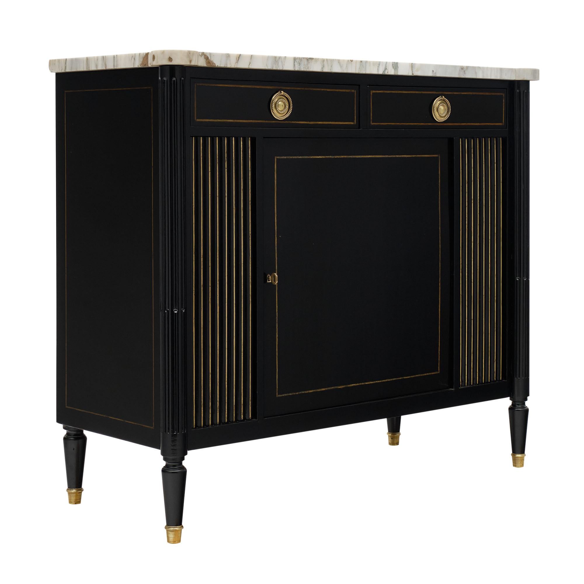 Buffet from France made of mahogany that has been ebonized and finished with a lustrous French polish. The brass inlays throughout add classic detail with finely cast bronze hardware and feet. The top is an intact Carrara marble top. There are two