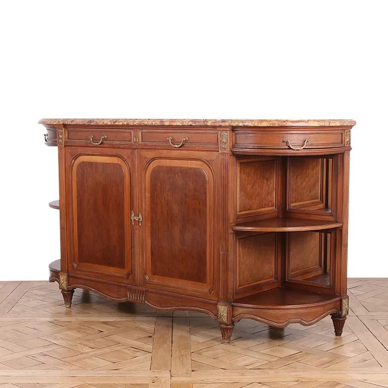 Questo splendido buffet in stile Luigi XVI, realizzato in pregiato mogano Plum Pudding, emana la classica eleganza francese. Con una superficie di marmo riccamente venata, il pezzo bilancia la raffinatezza con la funzionalità. Le ante dell'armadio