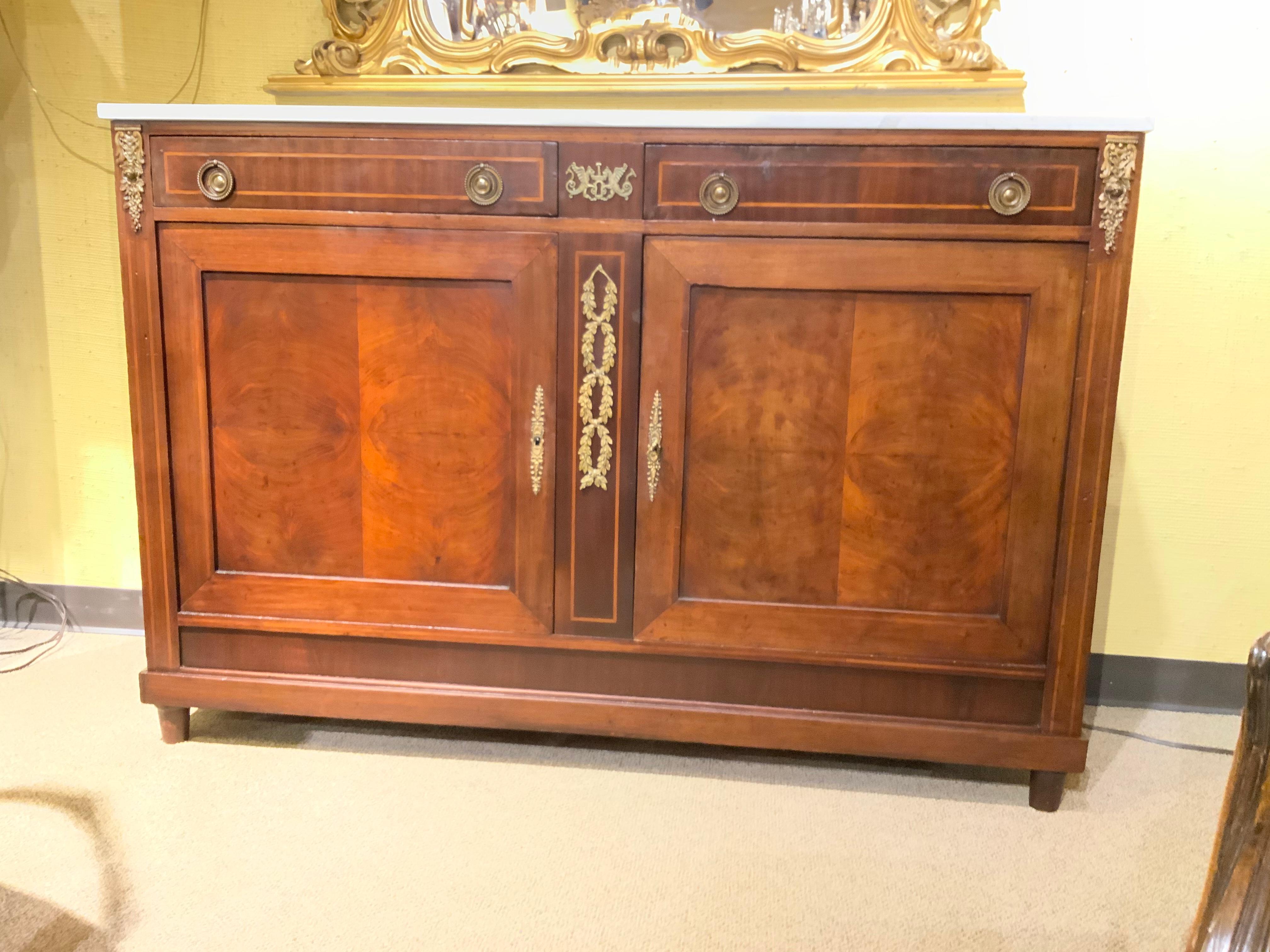 This piece is made of beautiful crotch mahogany with a deep patina.
The bronze hardware is original and in great condition. The marble has
No chips or repairs. The drawers move easily for sliding open. The doors
Open wide for good storage and it