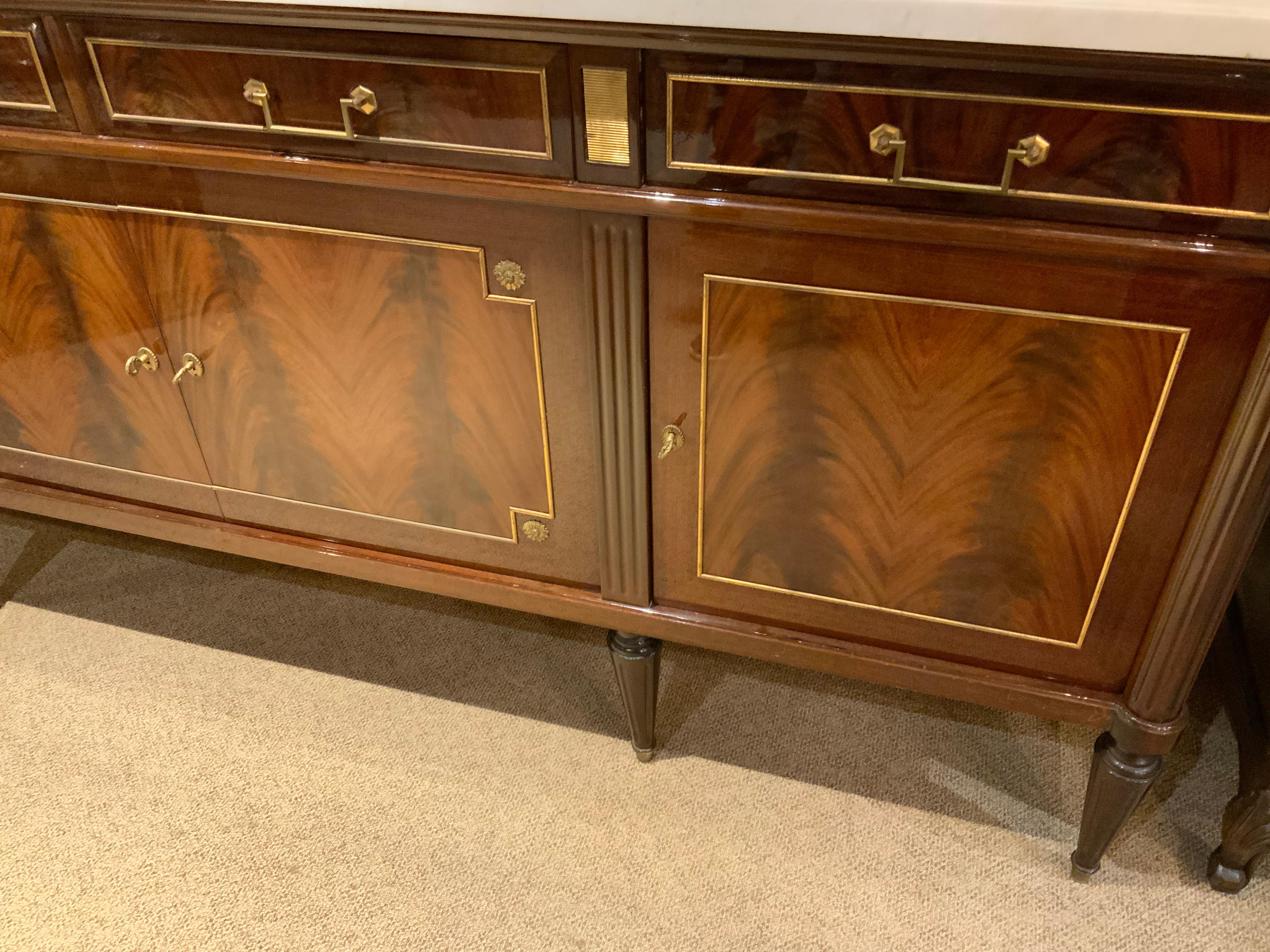 The excellent quality of the mahogany used to craft this beautiful 
Piece makes it exceptional. The white marble top with pale gray
Veining is in fine condition without restoration.  It has four
Drawers that move easily and four doors that open to