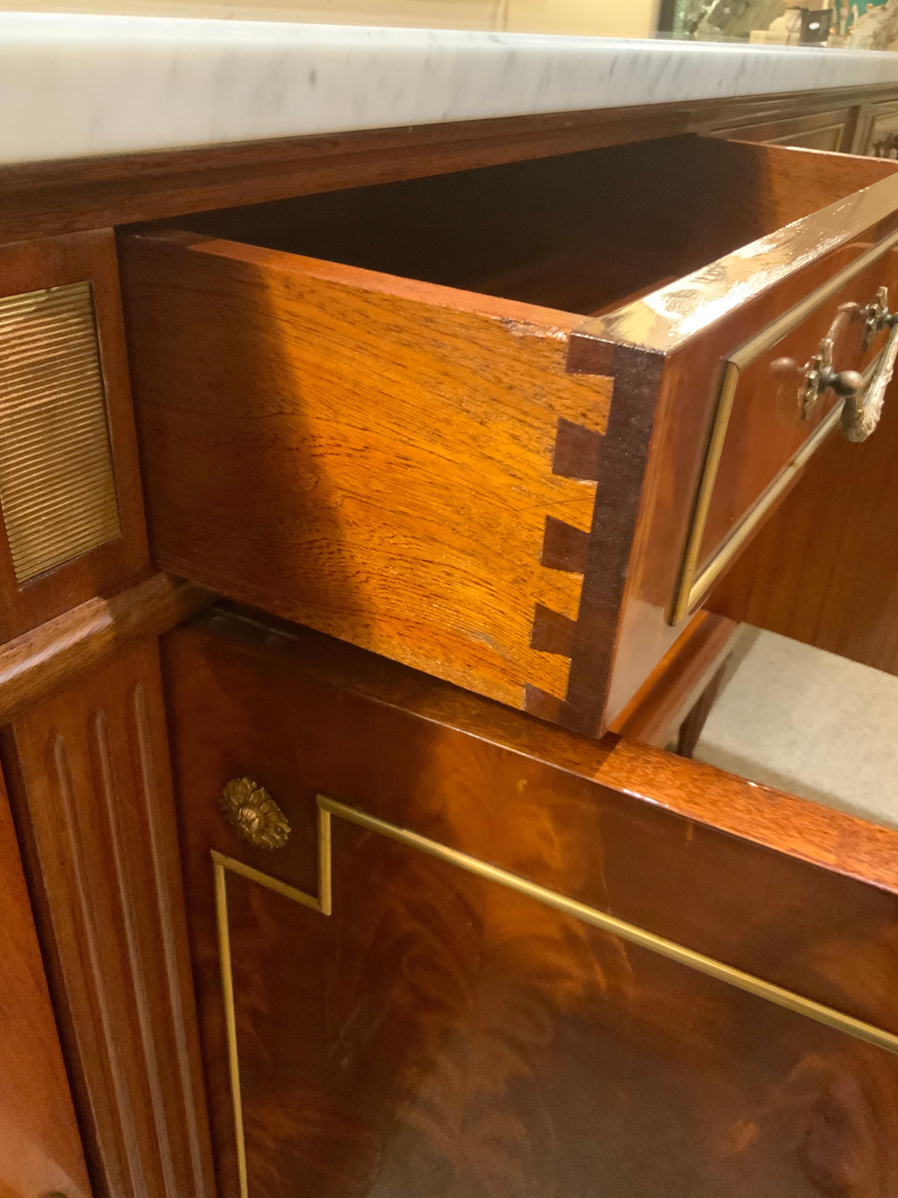 Credenza in stile Luigi XVI realizzata in pregiato mogano crotch con un bellissimo piano in marmo bianco. L'armadietto è dotato di un ottimo spazio per riporre gli oggetti, grazie ai ripiani presenti al suo interno.
Ha quattro porte che si aprono