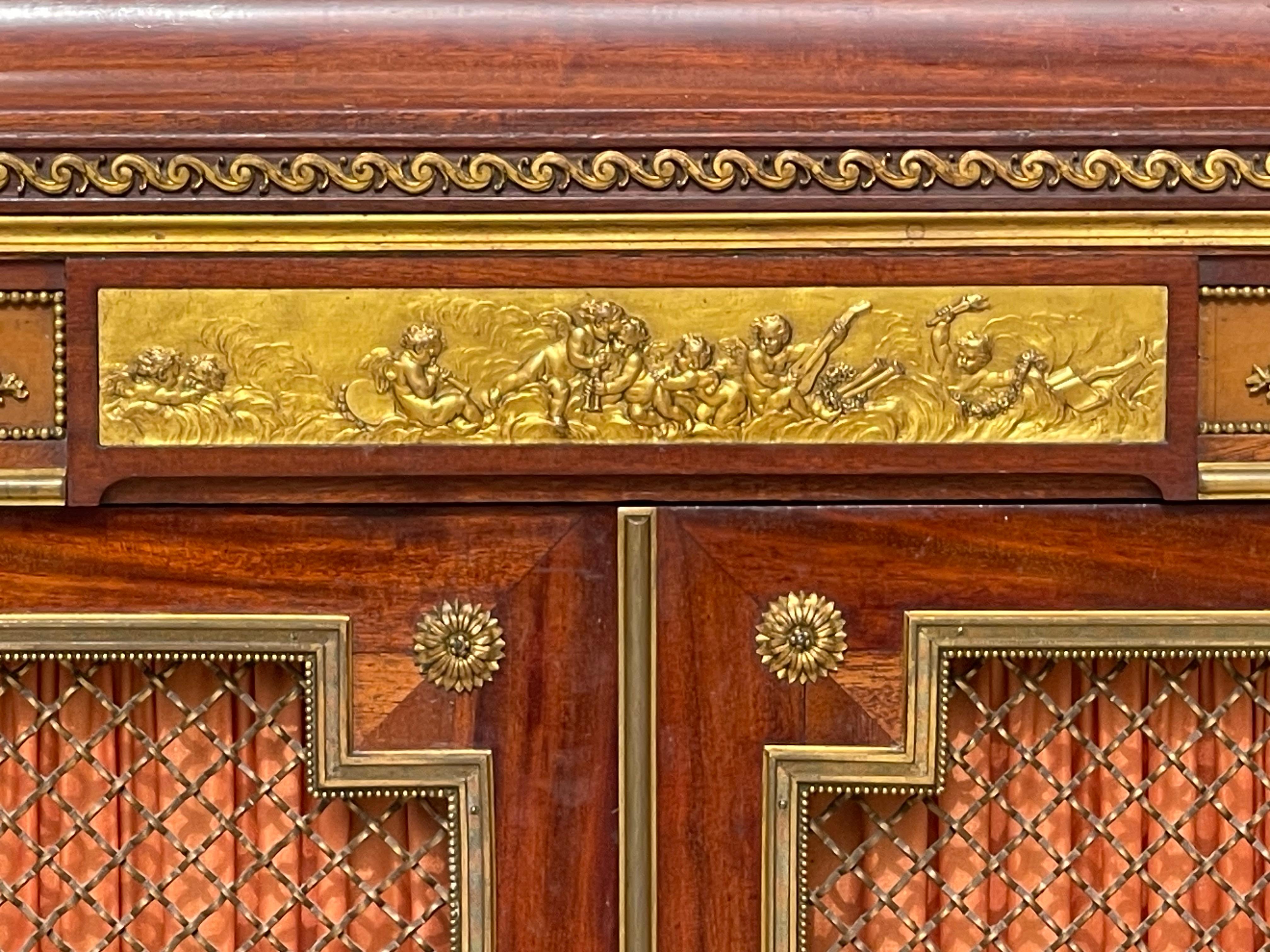 Mahogany and gilt bronze sideboard with two Louis XVI style mesh doors from the Napoleon III period with sea green marble top. The quality of the carving is remarkable on this piece of furniture. There are two shelves inside the cabinet. Furniture