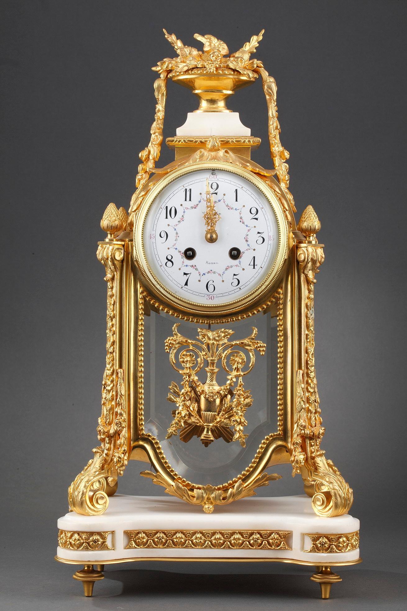 Important gilt bronze clock with crystal and white marble cage. The white enamel dial with garlands of flowers signed 