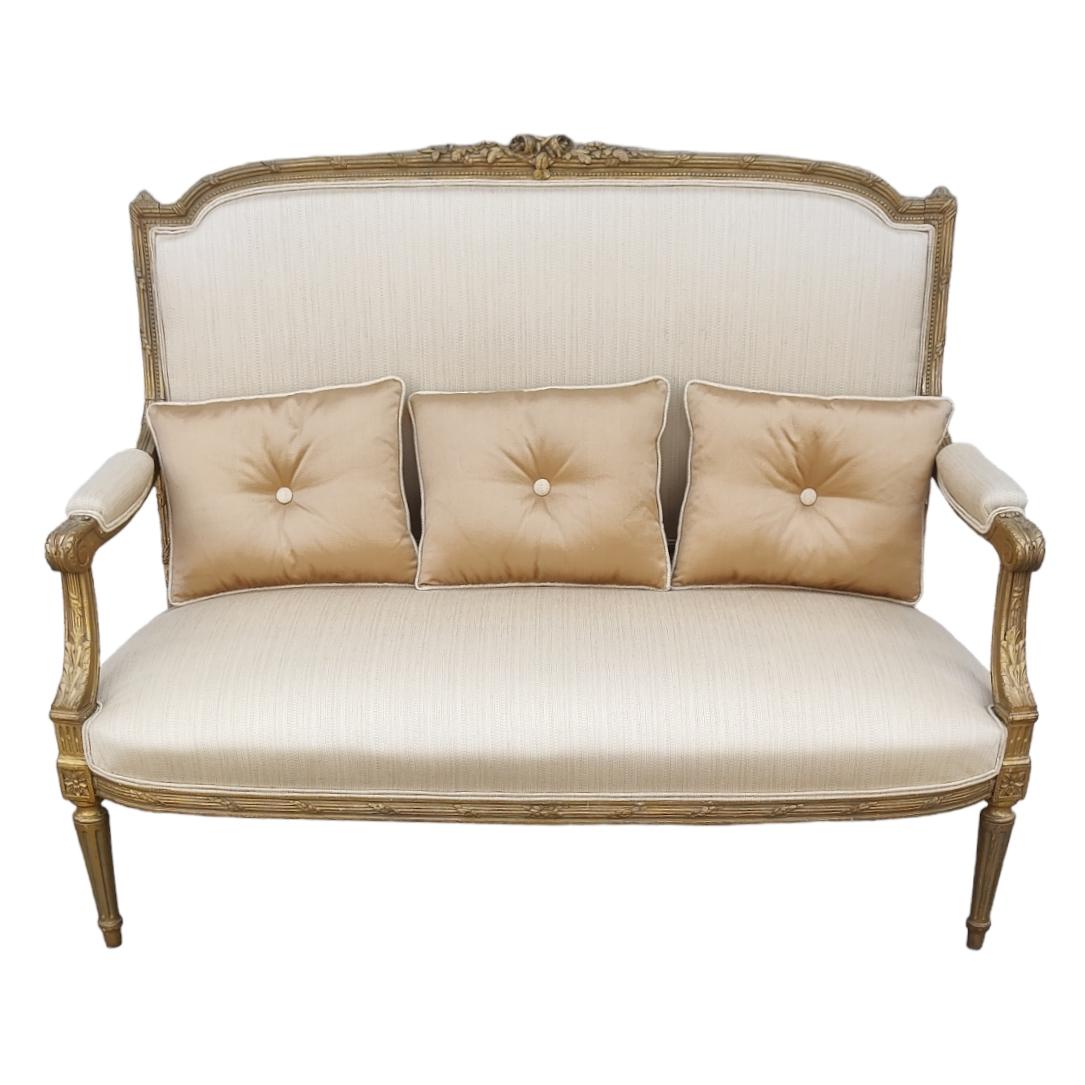 Causeuse à canapé de style Louis XVI. 

Il s'agit d'un excellent canapé qui a été retapissé en utilisant la méthode traditionnelle des sommiers à ressorts dans l'assise. La dorure du bois est d'origine, bien qu'elle ait été retouchée dans de petits