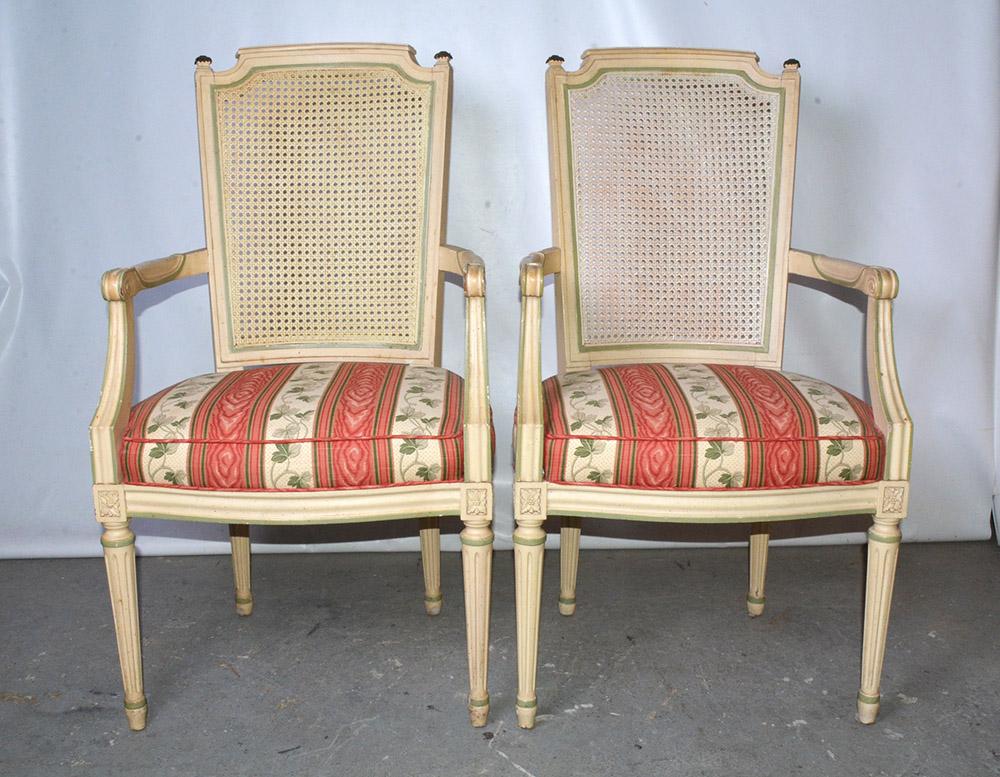 Pair of painted Louis XVI style armchairs with generous proportions with caned backs and upholstered seats. These stylish chairs most often referred to as 