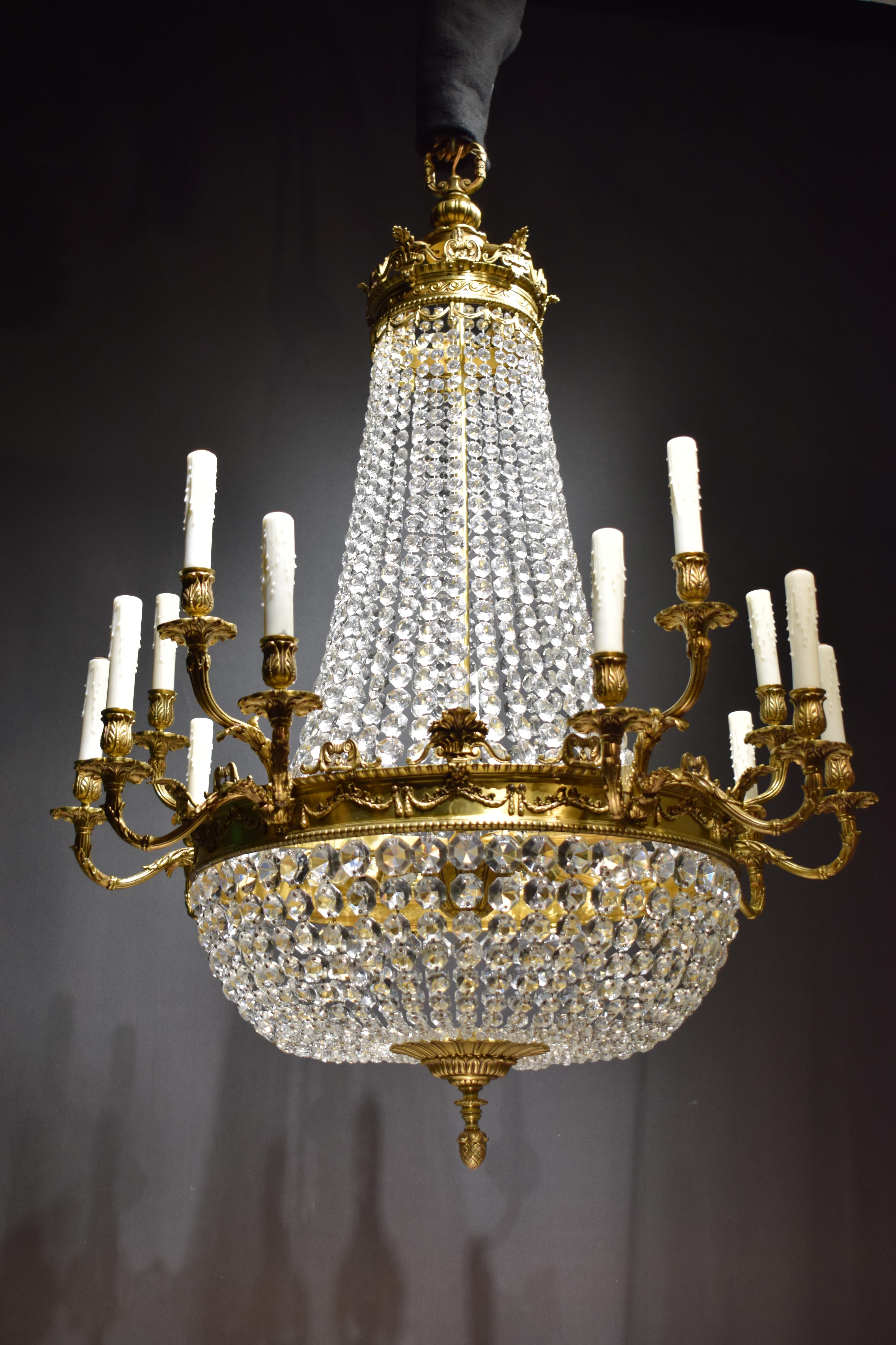 Ein hervorragender Kronleuchter im Louis XVI-Stil aus vergoldeter Bronze und Kristall. Der Hauptkreis ist mit Säumen verziert, die fünf Gruppen von drei Armen bilden. Die achteckigen Ketten bilden den birnenförmigen Körper. Stilisierte Krone aus