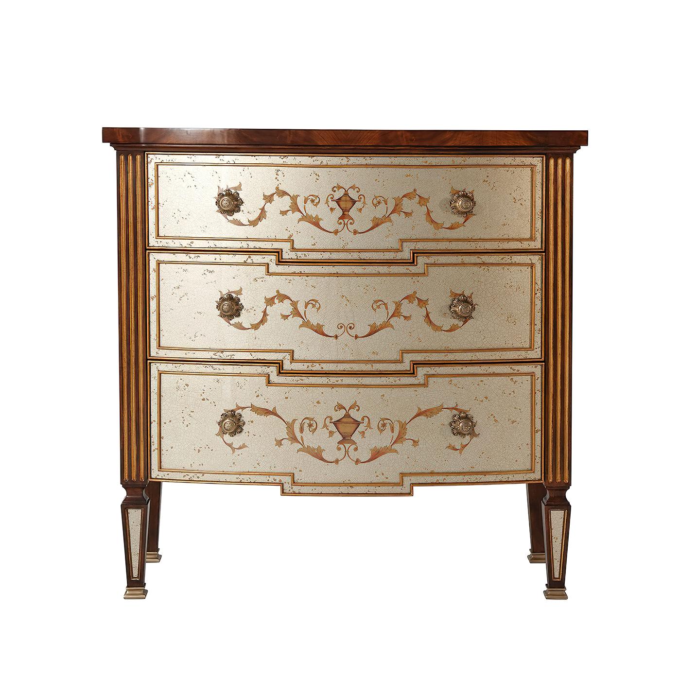 A flame mahogany and silvered verre églomisé chest, with gilt decoration of trailing vines with three graduated bowed and shaped drawers with finely cast brass handles on square tapering legs. The original Louis XVI.

Dimensions: 38