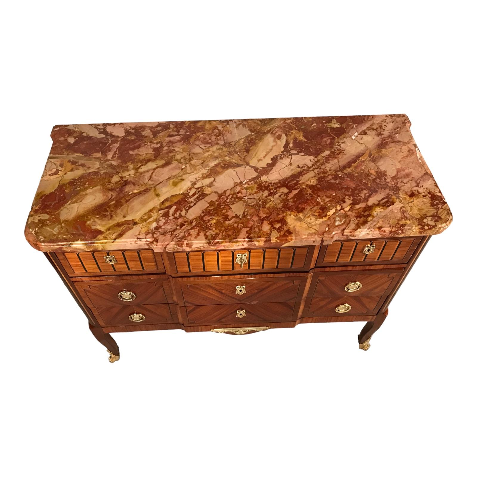 This exquisite Louis XVI-style chest of drawers originates from France and has been crafted around 1860. It boasts a stunning rosewood veneer adorned with marquetry bands made of mahogany and satinwood. The piece retains its original marble top,