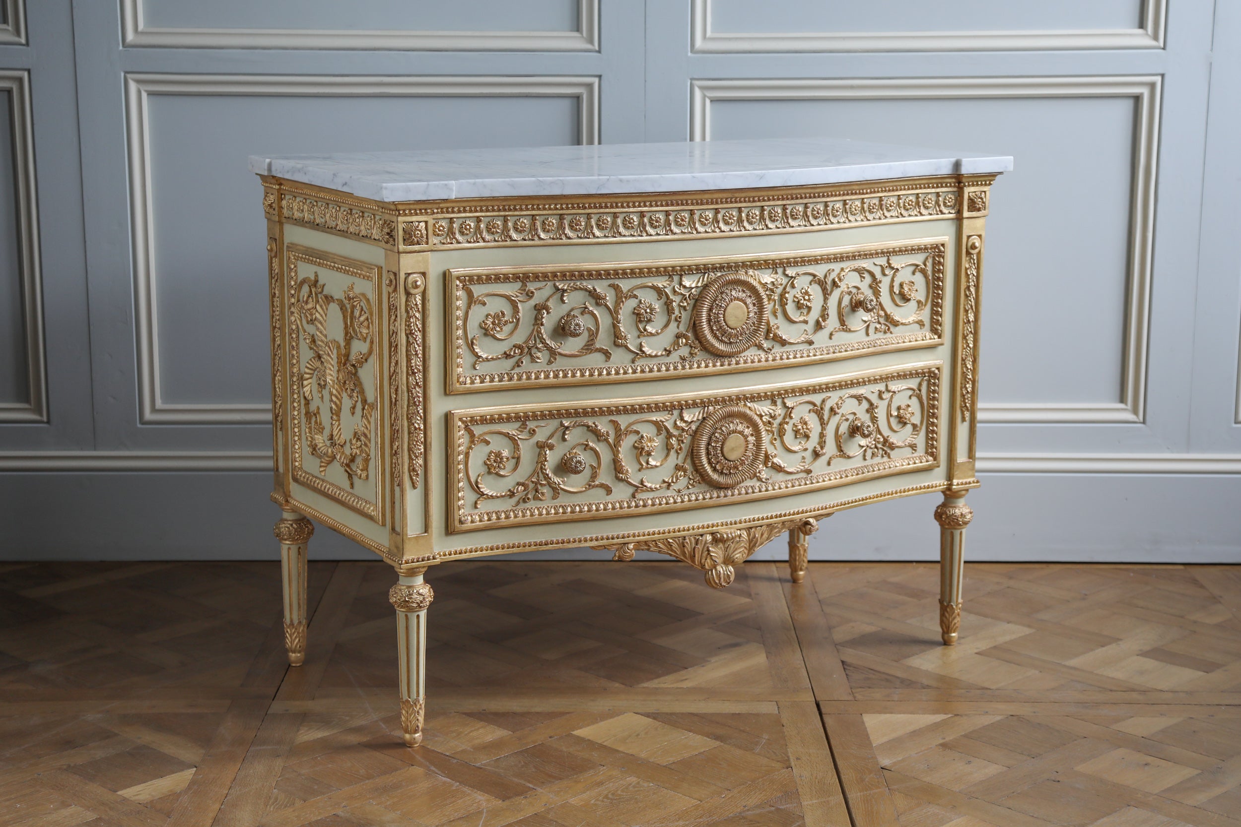 Hand carved and Hand finished Louis XVI style commode in polychrome finish.
Painted in a light French green with gold highlights.
with a 30mm Carrara Marble top
Fine details all around inspired by ancient Greece motifs.