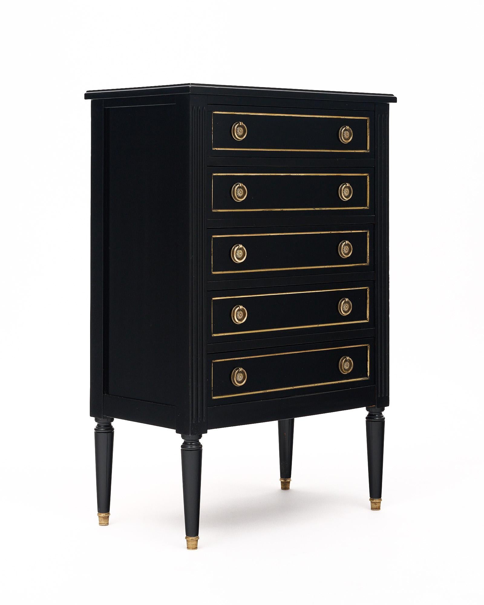 Chiffonier from France featuring five dovetailed drawers and gilt brass trims throughout. This piece is made of mahogany and has been ebonized with a lustrous French polish finish. The sides are fluted and four tapered, brass capped legs support the