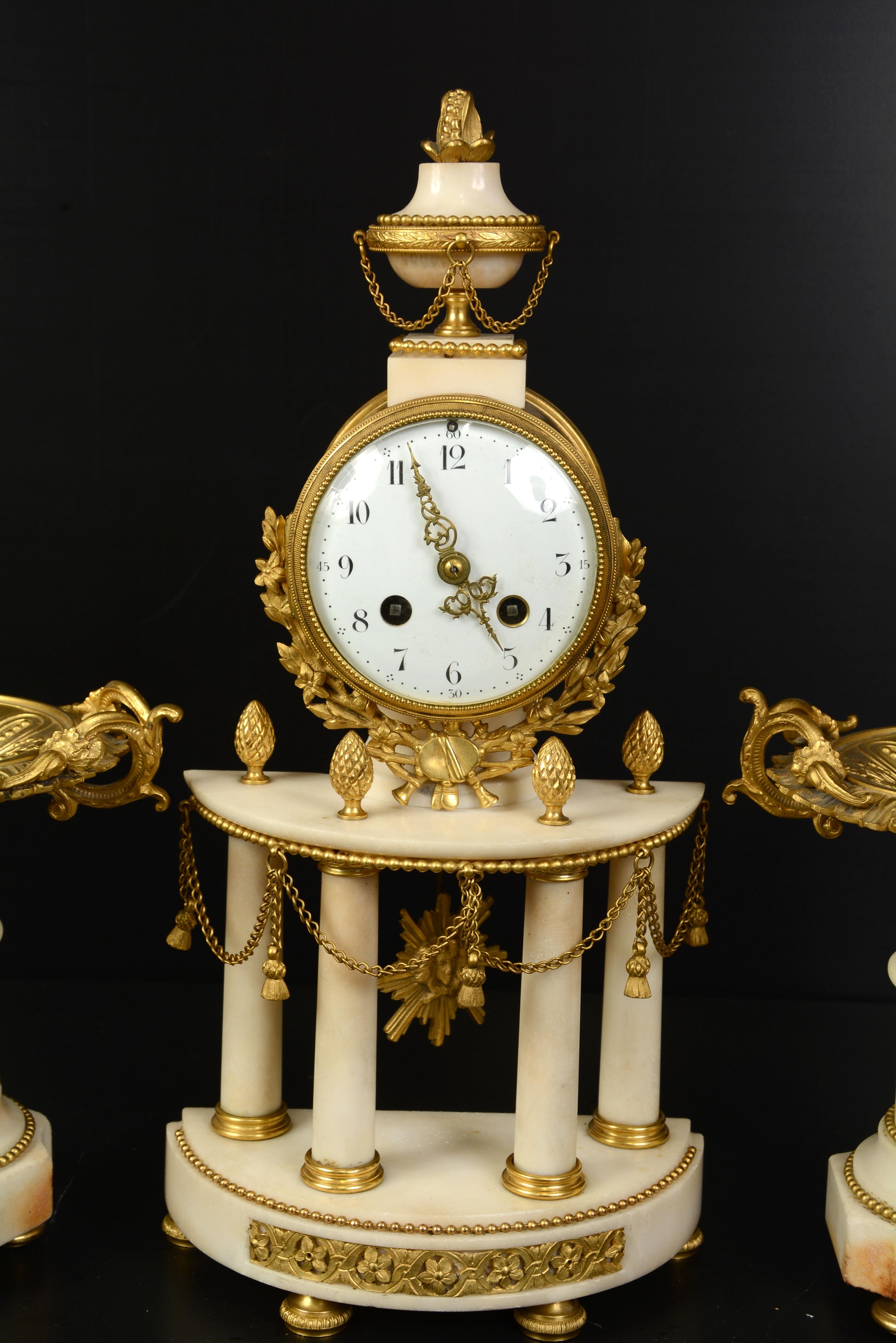 Zwei Tassen auf Sockeln und eine Uhr.
Der französische Stil, der als Louis XVI bekannt ist, zeichnet sich durch seine Inspiration durch den Klassizismus aus und umfasst etwa den Zeitraum von 1760 bis 1789. Im 19. Jahrhundert wurden zahlreiche