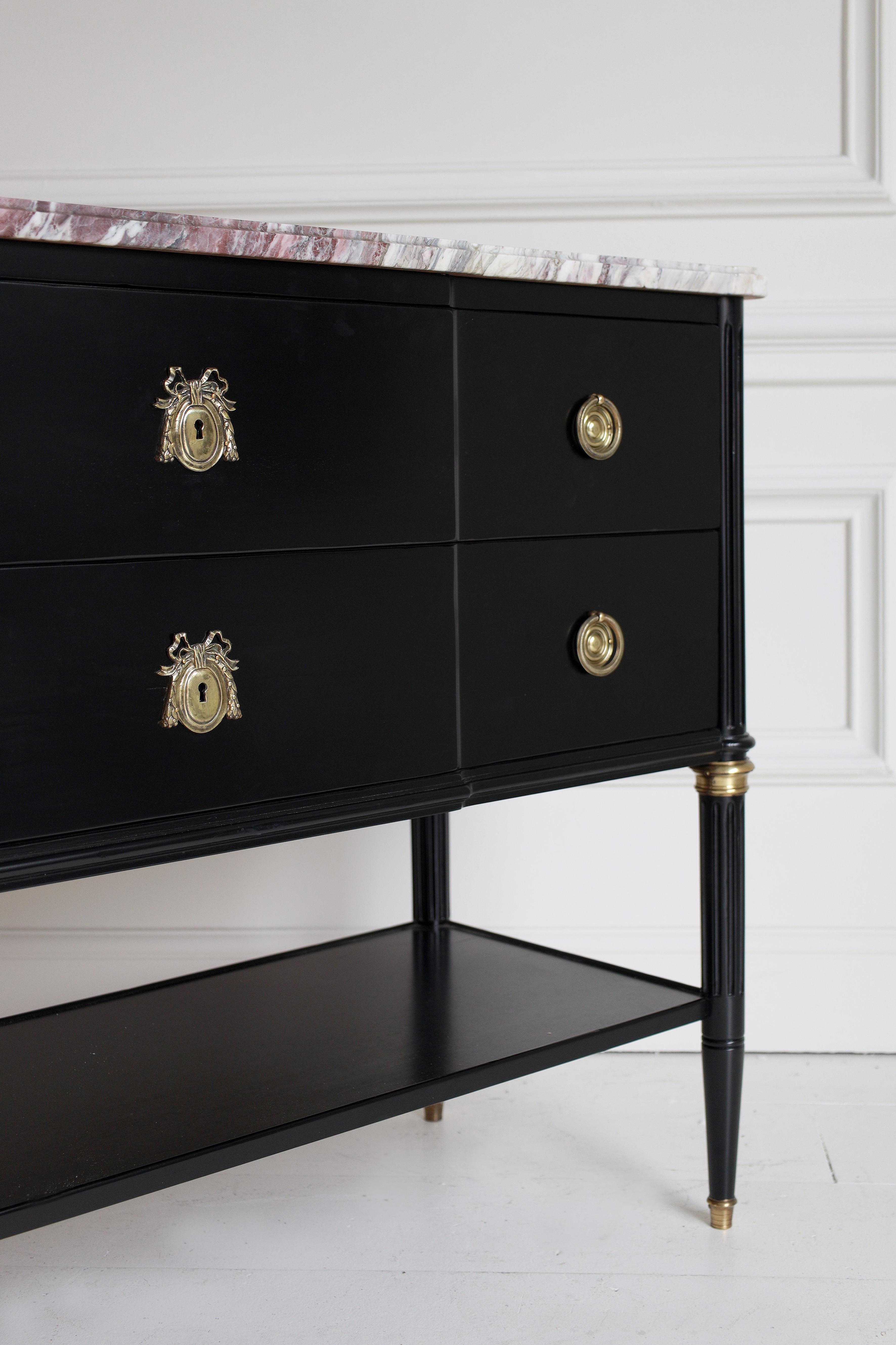 An elegant French 19th century Louis XVI st. mahogany style commode. The chest is raised by circular tapered fluted legs with fine ormolu sabots and top caps. Each leg is connected by a mahogany bottom tier with a raised edge. Above a mottled carved