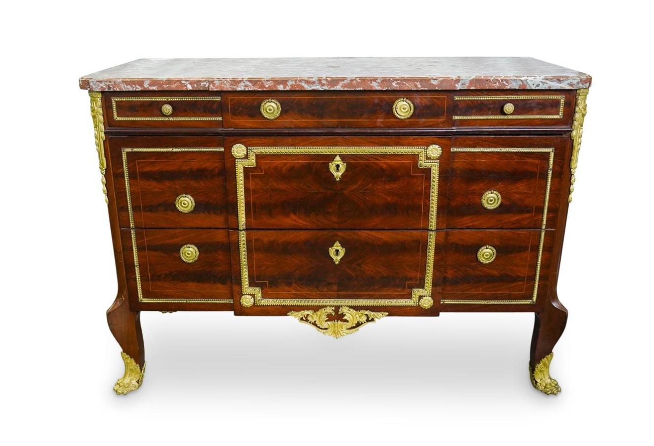 Una raffinata commode francese in stile Luigi XVI della fine del XIX secolo, dotata di ornamenti in bronzo ormoluto lungo i bordi dei cassetti e dei lati. Presenta tre cassetti piccoli e due cassetti grandi. La cassapanca poggia su piedi a zampa di
