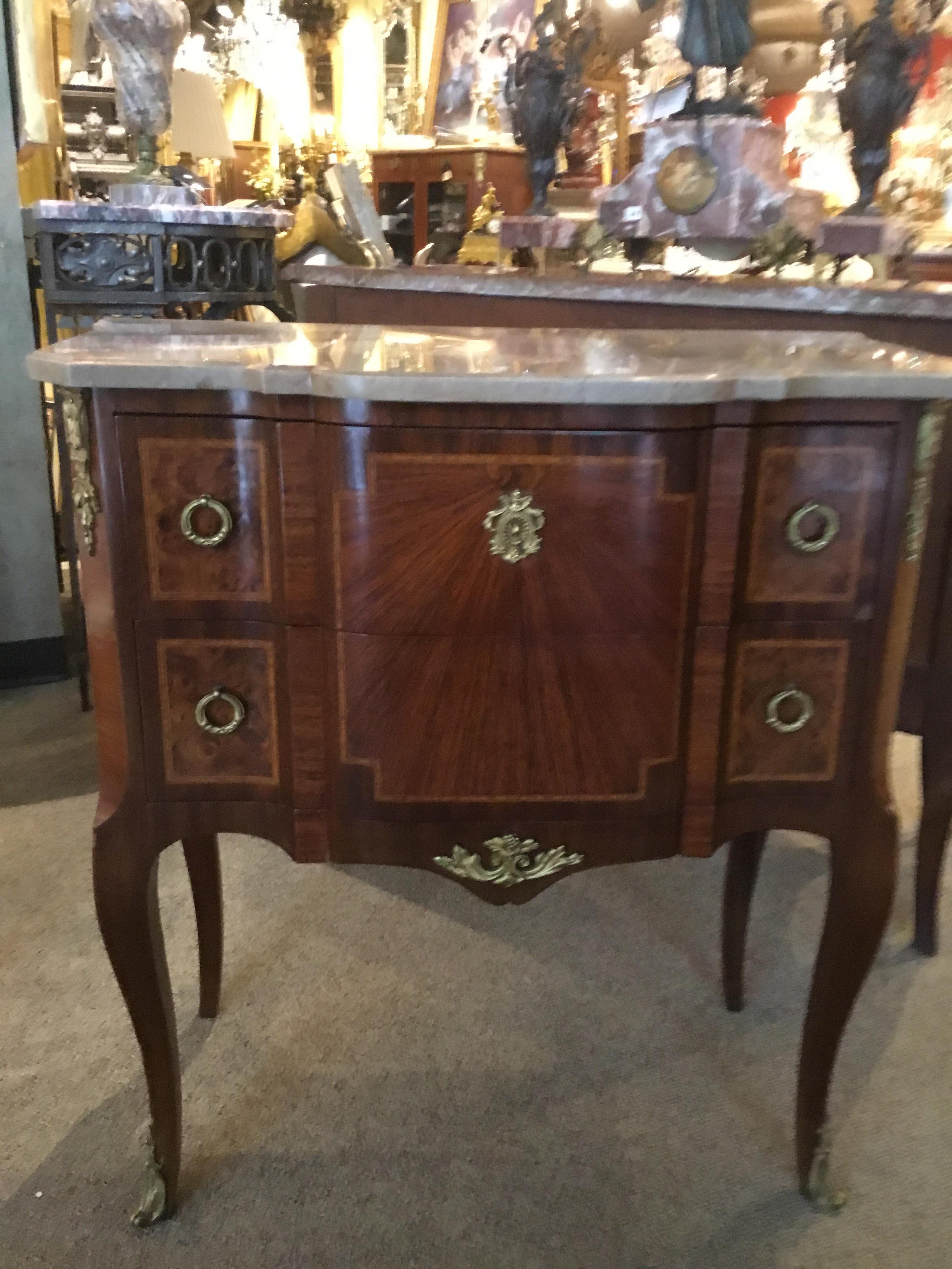 Beautifully shaped petite commode in Louis XVI style elevated on a graceful
Curved leg, having two drawers with gilt bronze adornments. Mahogany
and kingwood with satinwood banding enhance the over all.