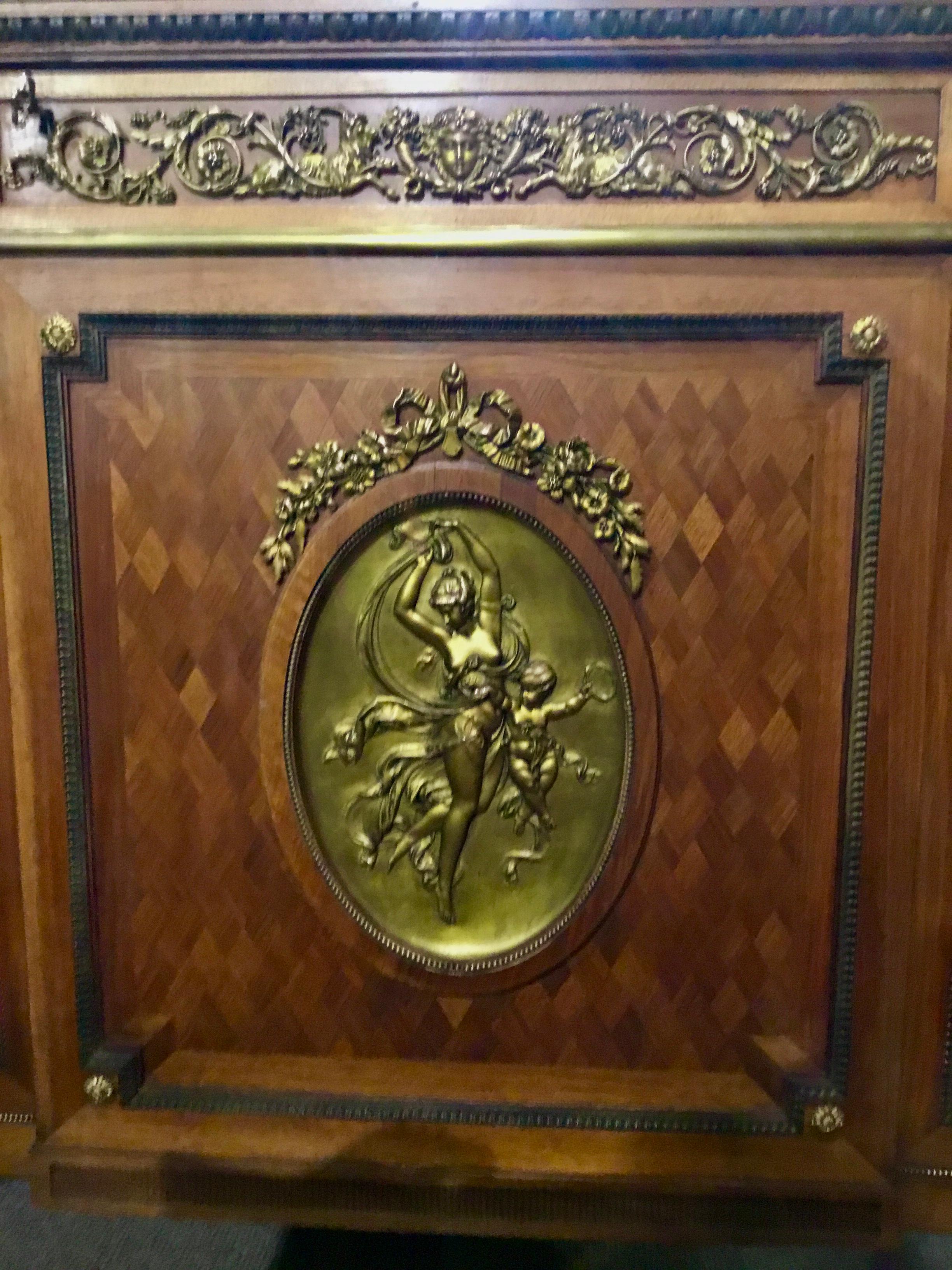 Beautiful marquetry work in kingwood and walnut, having three drawers
Inside two doors. A beautiful cameo with bronze doré figure of woman
And an angel decorate the center front of the cabinet. It has a key that
Operates all the doors.