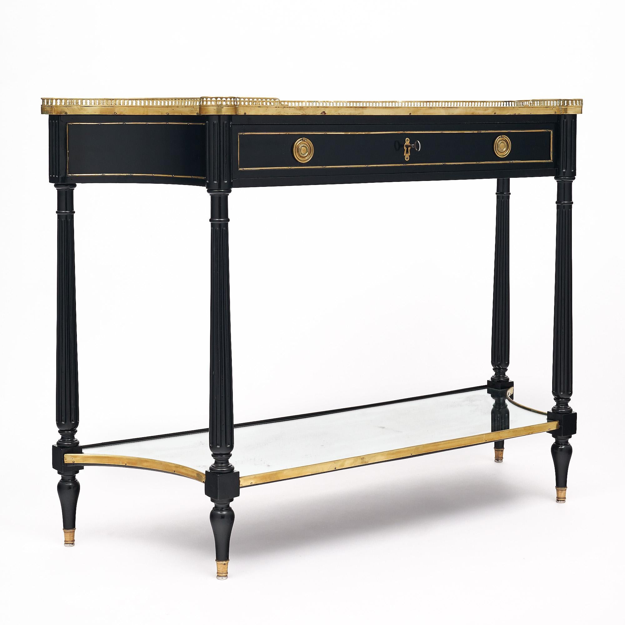 Console table from France in the Louis XVI style. This piece has been ebonized and finished in a lustrous Museum quality French polish. There is one dovetailed drawer that has a working lock and key. The hardware and trim throughout is all finely