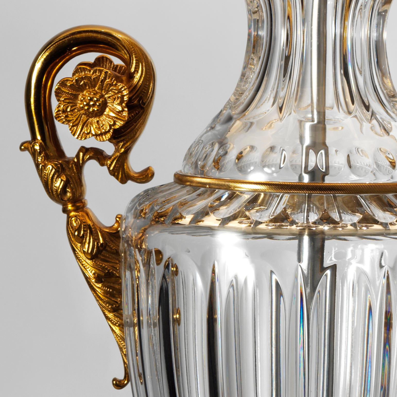 This Louis XVI style cut crystal and gilt bronze lamp by Gherardo Degli Albizzi features an amphor shape made by three crystal sections and fully chiselled bronze handles centered by flower decoration. Crystal sections are separated by gilt bronze