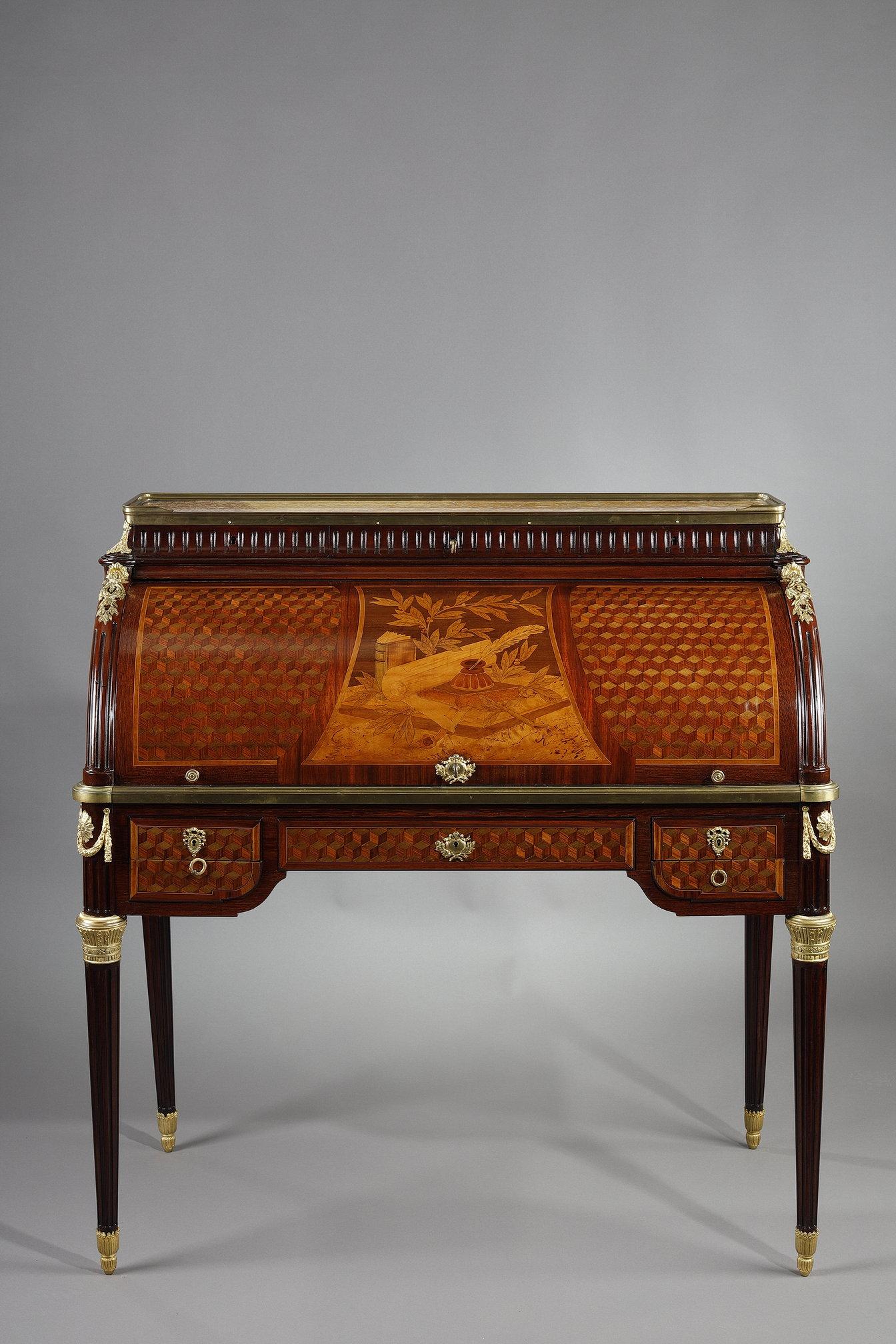 Elegante scrivania a cilindro in stile Luigi XVI in mogano e impiallacciatura di palissandro, decorata con un intarsio di motivi geometrici in prospettiva cubica. La parte anteriore del cilindro presenta una composizione a intarsio che illustra un