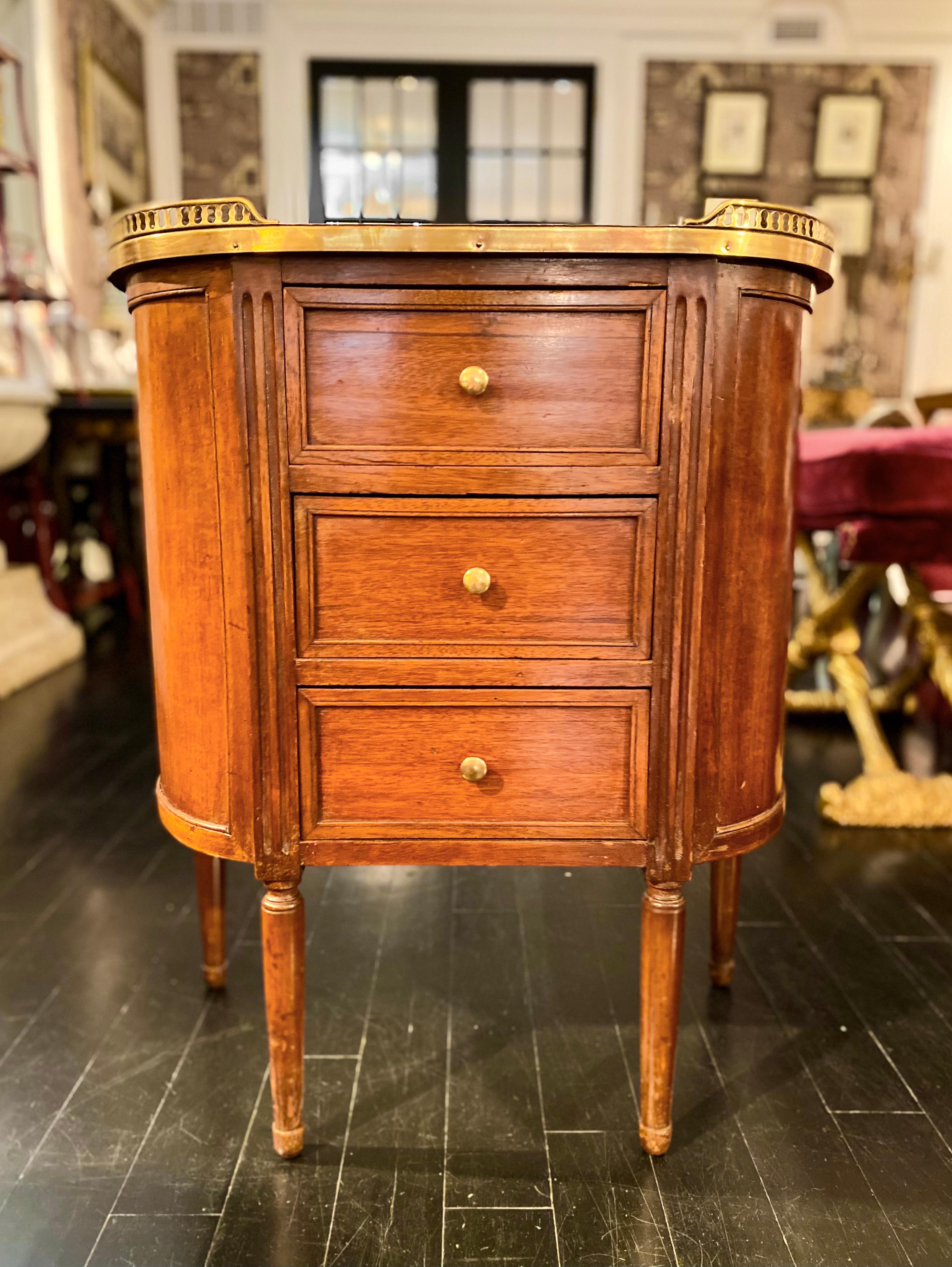 Louis XVI Style cabinet or commode chest of drawers with marble top and bronze gallery. 
Demi-lune white marble top with rounded corners surrounded by a bronze pierced gallery. The cabinet is fronted by three drawers. It is mounted on four Louis