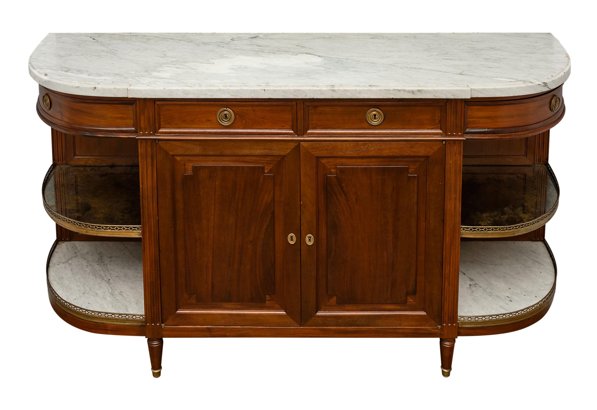 Louis XVI style demilune buffet made of mahogany with a Carrara marble top, open shelving, and brass galleries. 

This piece has wear to the marble top due to antique condition, including chips.