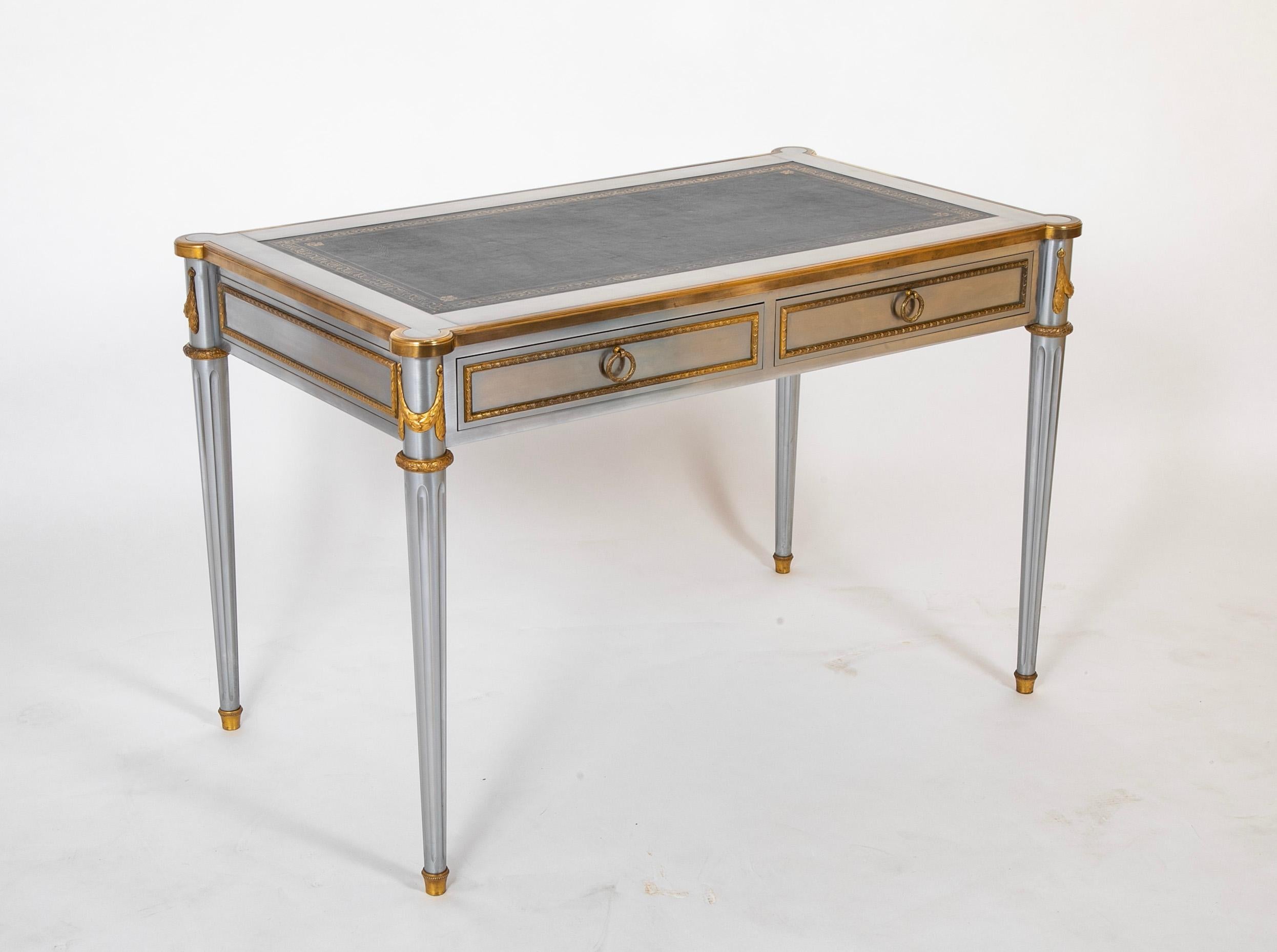    Extraordinary mid-century modern stainless steel and bronze writing table, desk, or bureau plat designed by John Vesey (American 1924-1992). Made in the grand neoclassical French Louis XVI taste featuring polished gilt bronze trim and an iconic