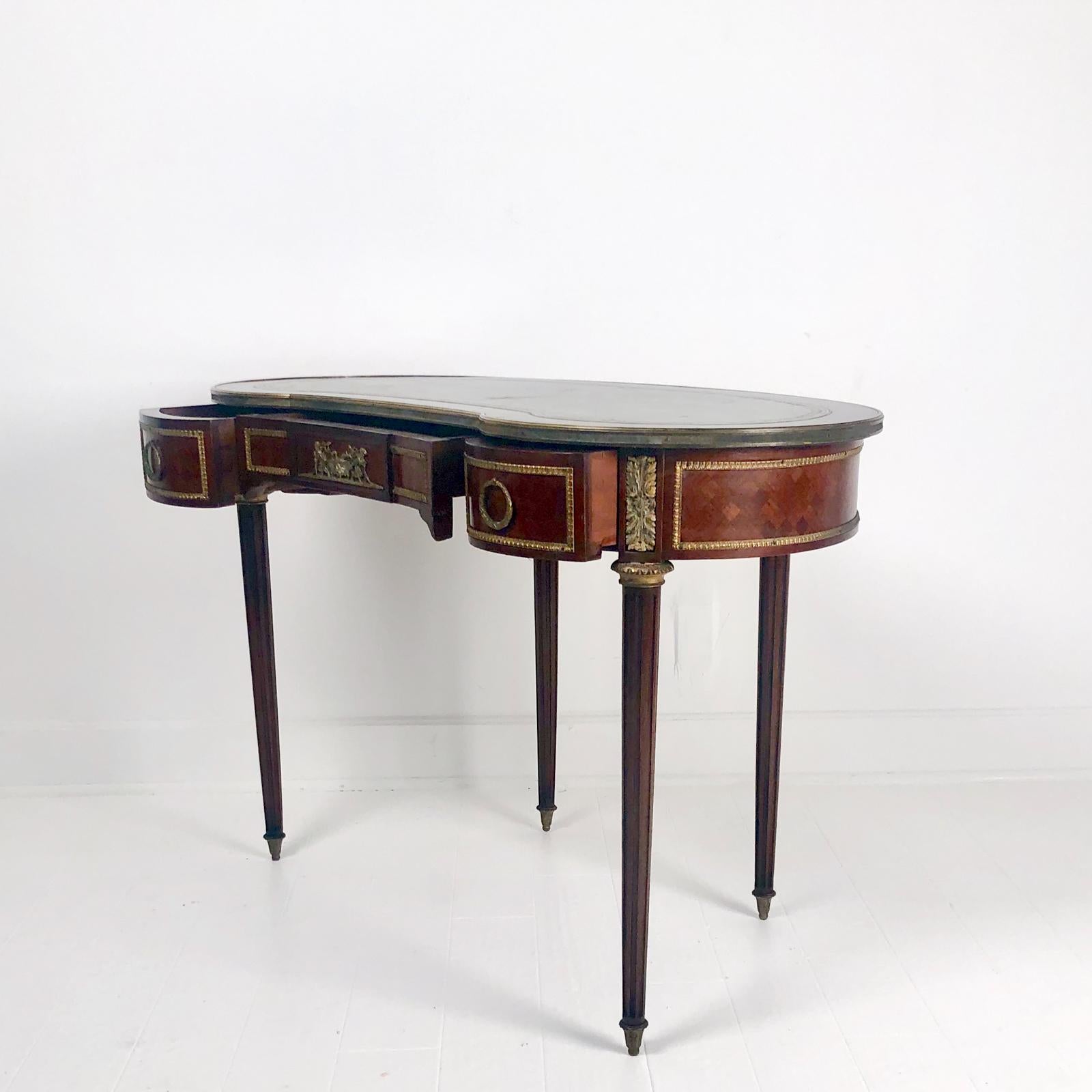 An early 20th century Louis XVI style French kidney shaped desk or dressing table, with a leather top and 3 drawers, circa 1920.

