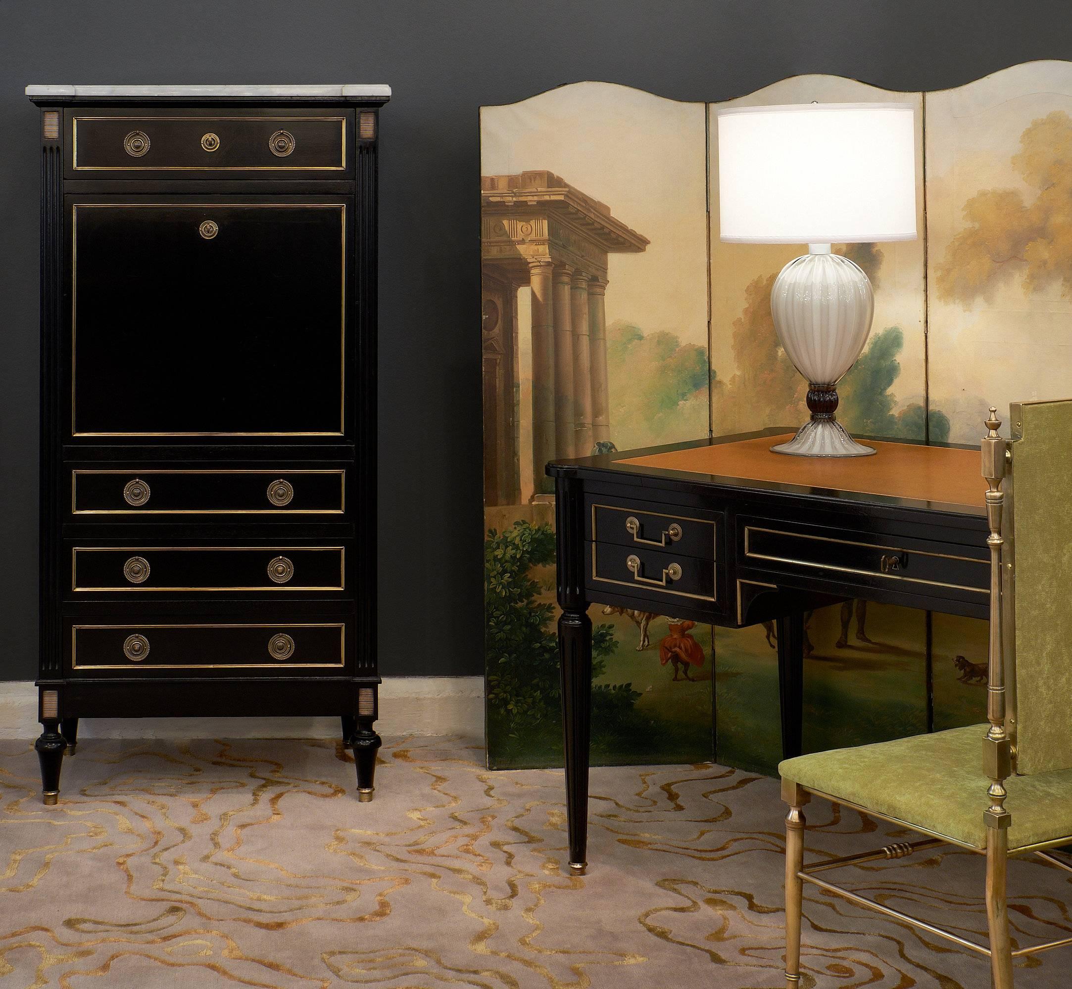 French antique Louis XVI style desk with leather surface in a tan color, embossed with a 23-karat frieze. It is made of ebonized mahogany and finished with a museum quality French polish. Two pull out extensions, also covered in leather, complete