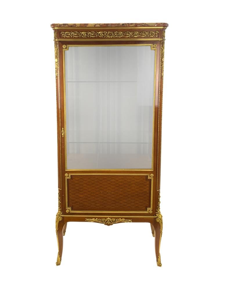 Exquisite quality 19th century display cabinet, Topped with marble above scrolling foliage, a single door opening to two glass shelves, with gilded ormolu mounted all over the vitrine.

Stamped KRIEGER PARIS to the inside of the door.