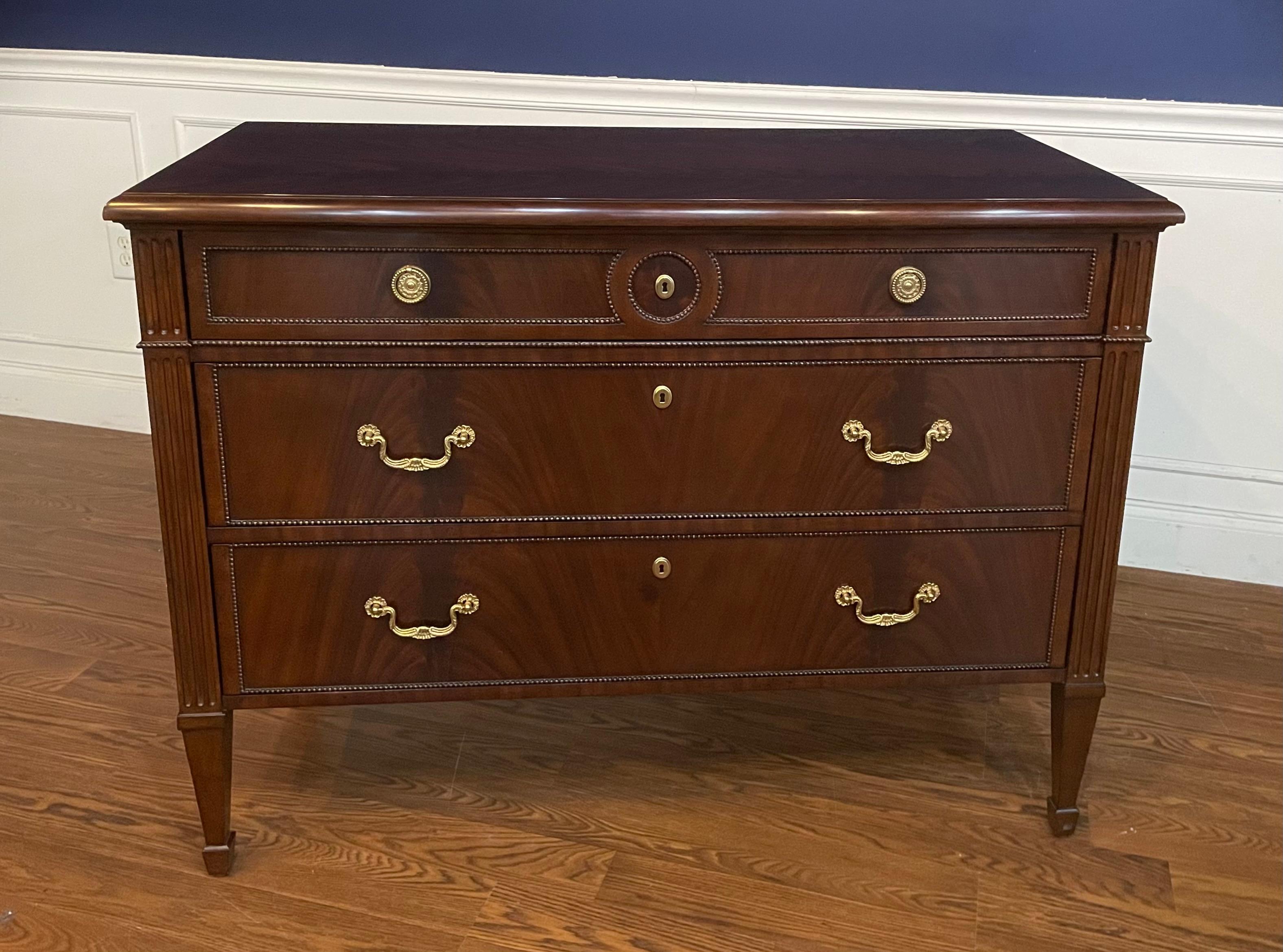 This is a Louis XVI style drawer chest. It features three drawers, solid brass hardware and faux key holes. The top, drawer fronts and sides have swirly crotch mahogany. The drawers are dovetailed and oak lined. The legs are classic Louis XVI