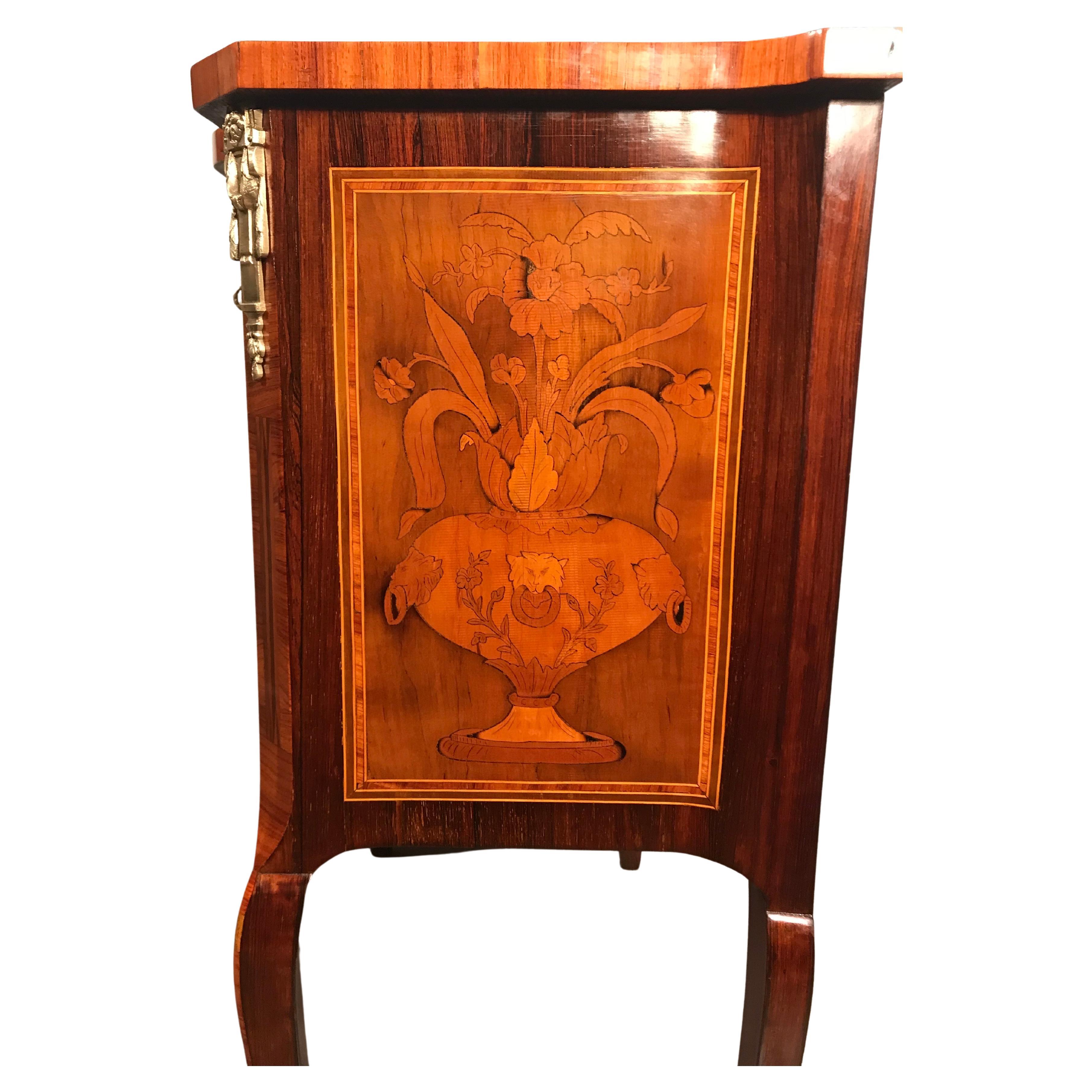 This small Louis XVI style dresser comes from France and dates back to the second half of the 19th century.

The two drawer commode stands on slightly curved legs which are decorated with foliate bronze sabots. The special part about this piece is