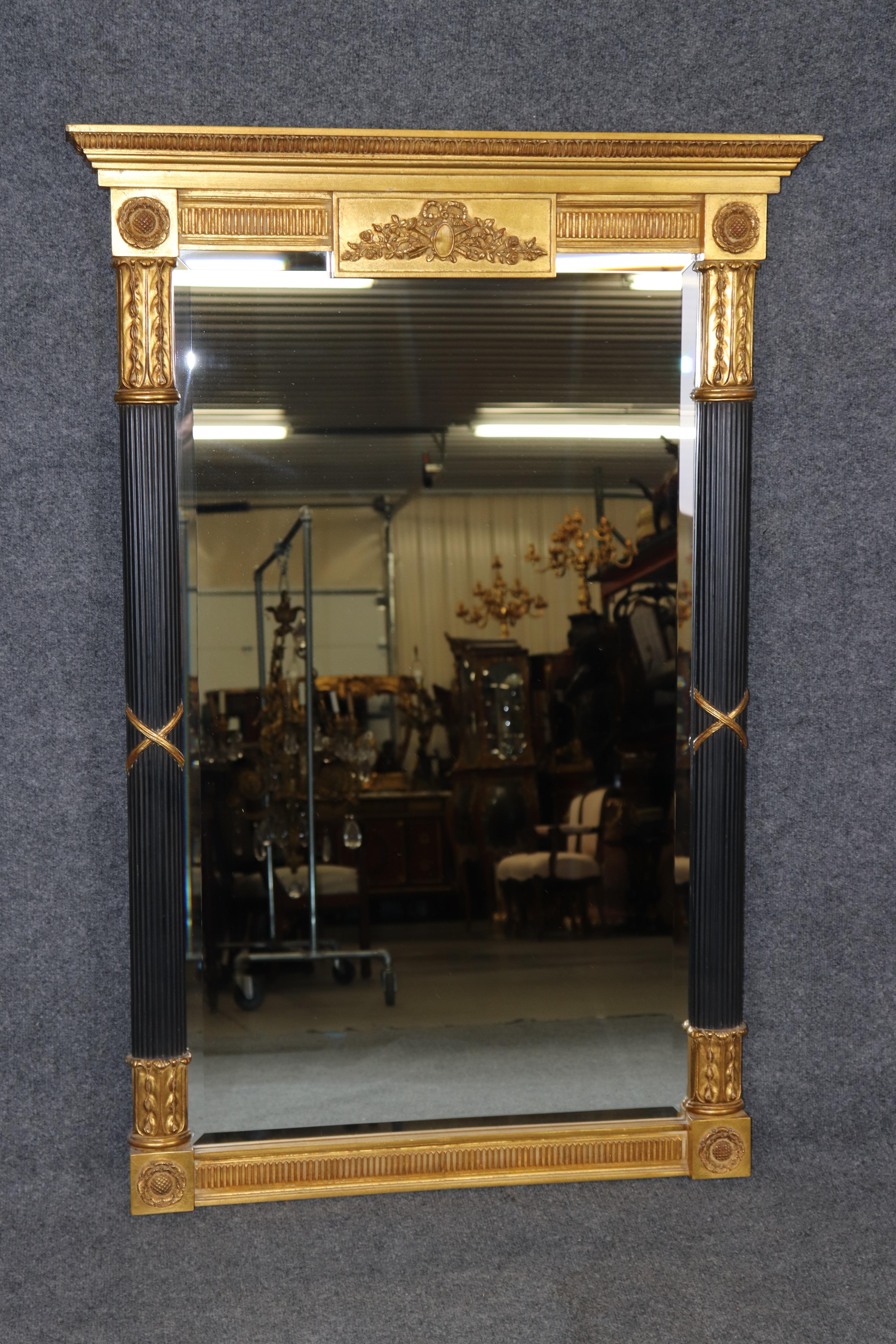 Dimensions - H : 50 1/2 in W : 34 1/2 in D : 3 1/2 in 

Exceptionnel miroir biseauté de style Louis XVI, ébonisé et sculpté en vermeil, par Carver's Guild, fabricant renommé de miroirs décoratifs et de décorations murales. Cette pièce exquise