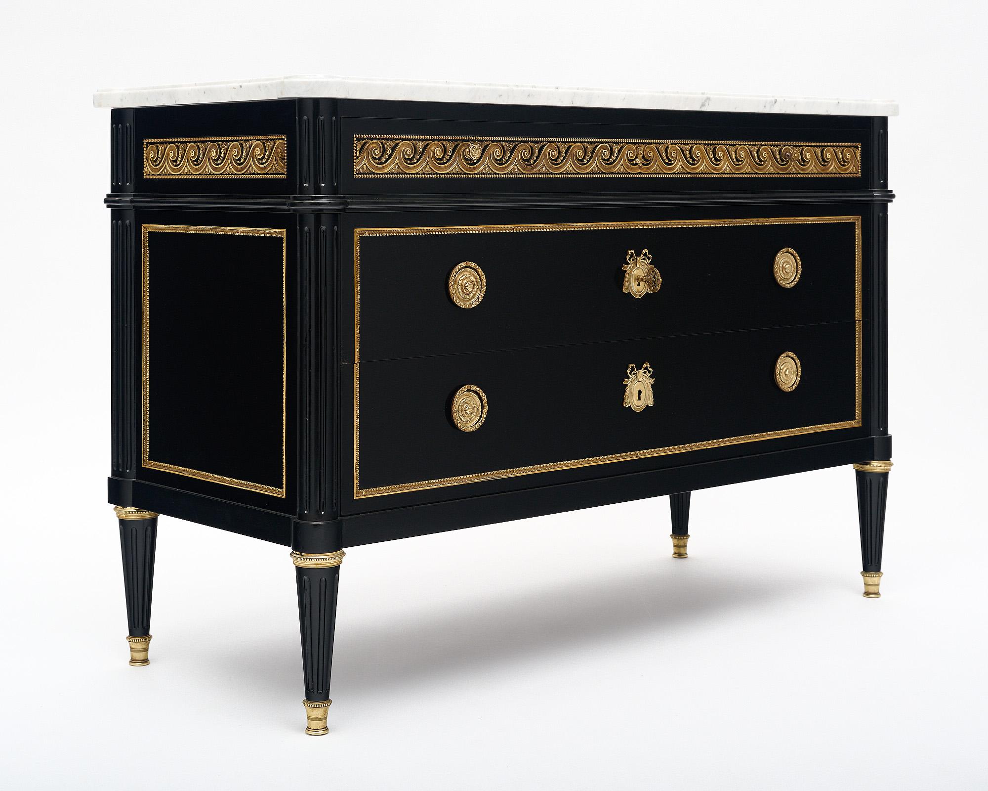 Chest of drawers; French; in the Louis XVI Style. This striking piece features three dovetailed drawers and is made of ebonized Mahogany that has been finished with a lustrous museum quality French polish. There is gilt brass trim and detailed