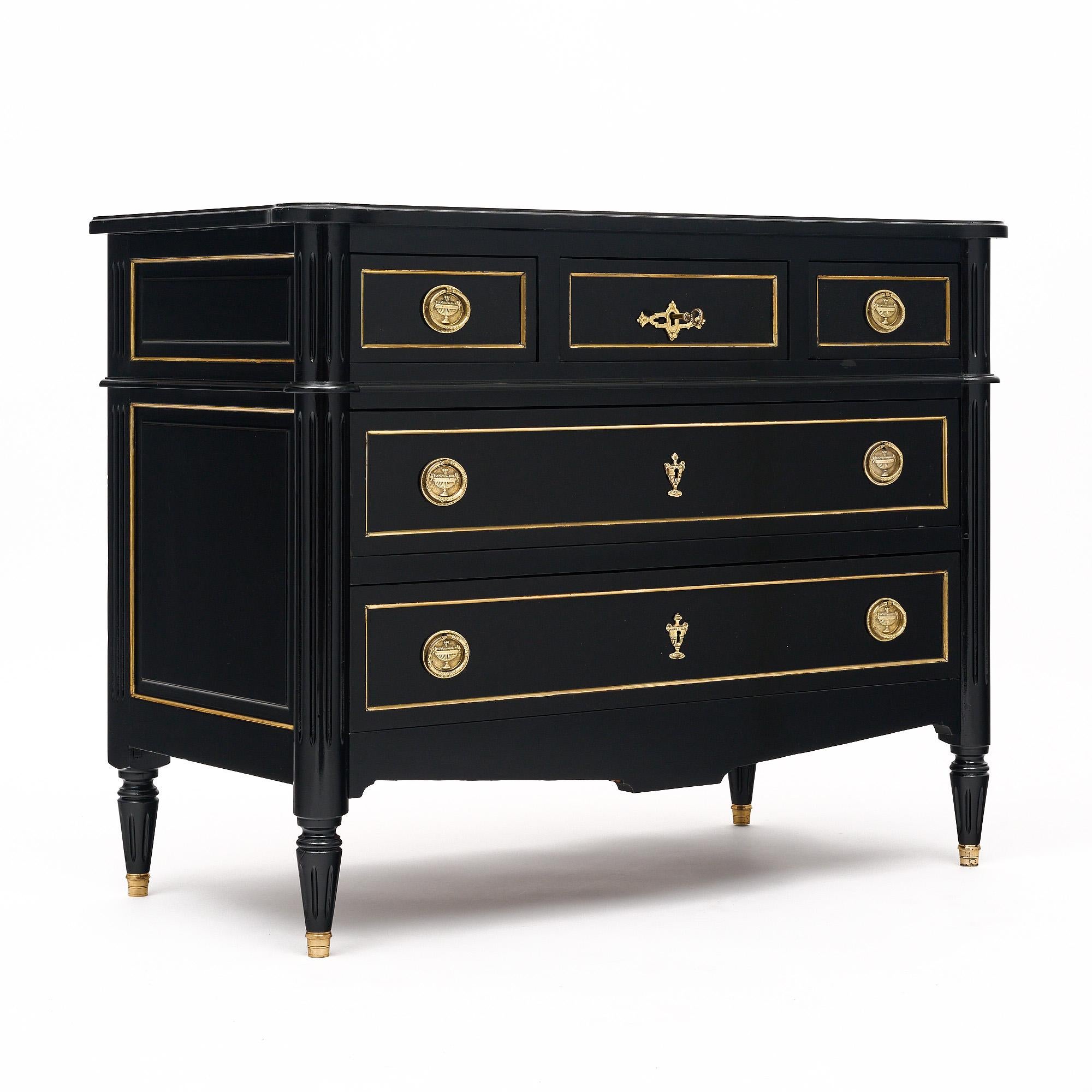 Chest of drawer from France in the Louis XVI style made of mahogany. This case piece has three small dovetailed drawers above two long dovetailed drawers. Gilt brass pulls and trims are found throughout. The top, middle drawer has a working lock and