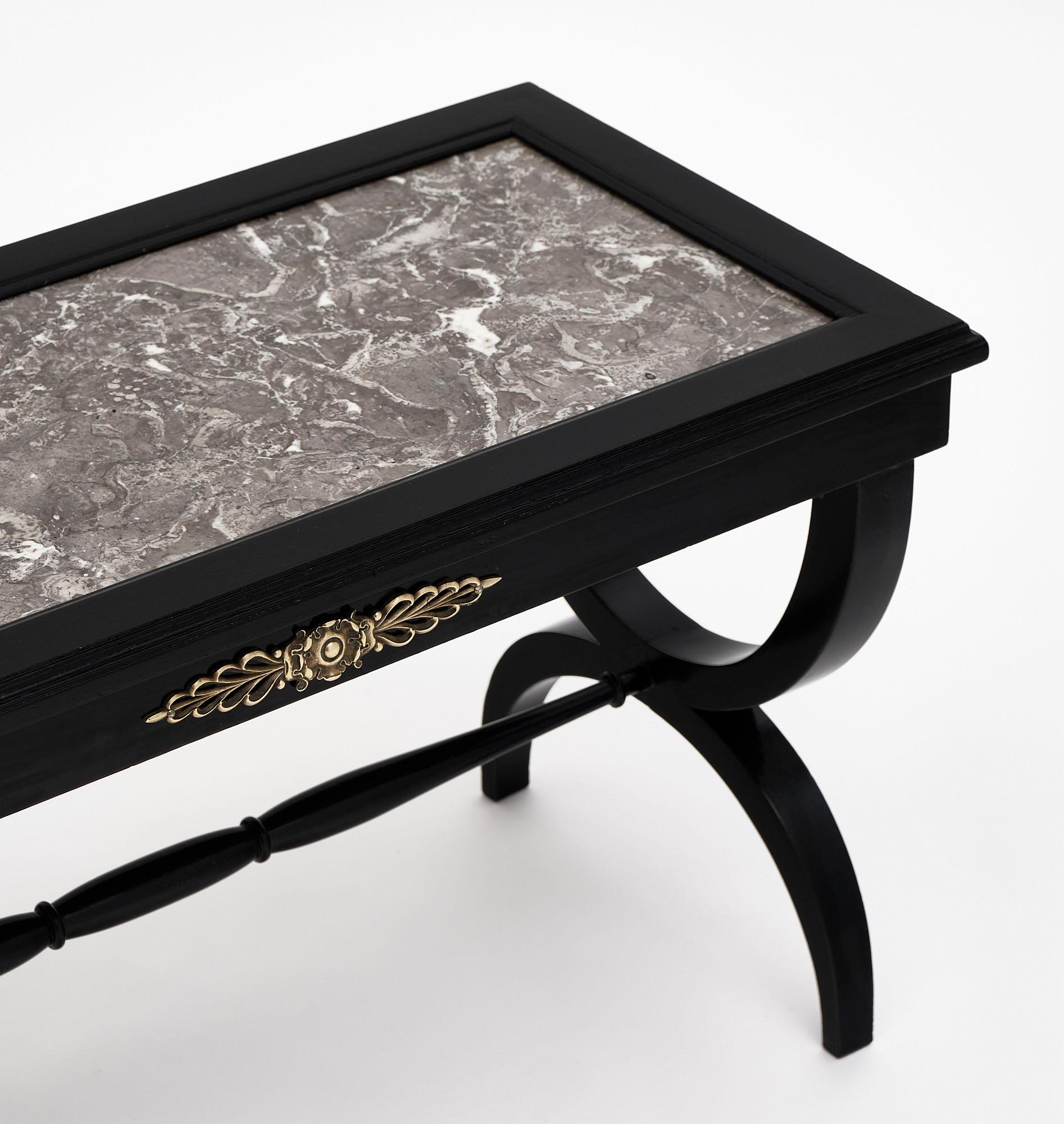 Louis XVI style ebonized coffee table from France made of walnut that has been ebonized and finished with a French polish. The finely cast bronze accents add a lovely detail and there is one dovetailed drawer. We love the inserted Sainte Anne gray