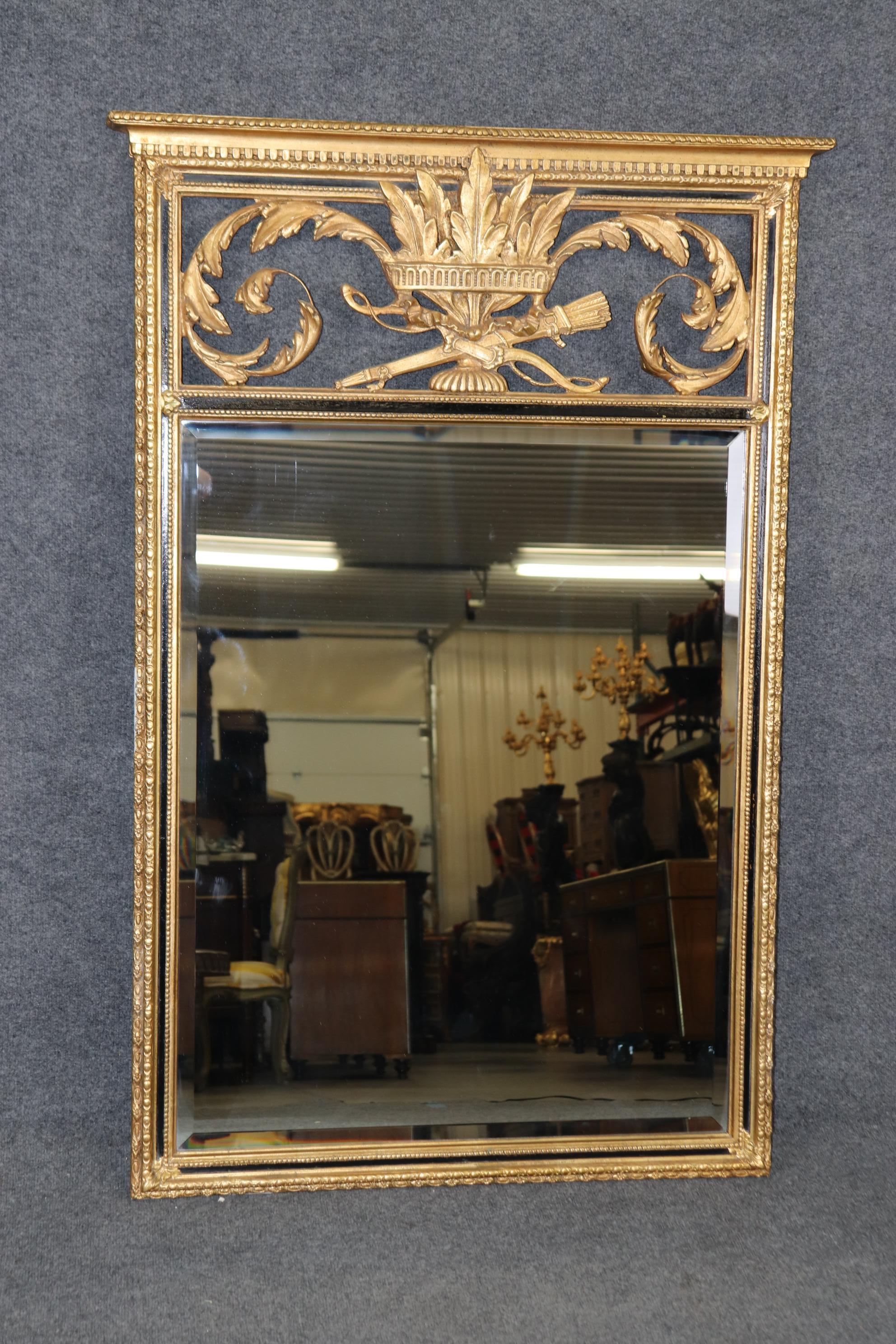 Dimensions - H: 54 1/4in W: 36 1/4in D: 2 3/4in

This Louis XVI Style Ebonized Gold Gilt Carved Trumeau Mirror By Friedman Brothers is truly a show stopper! If you look at the photos provided you will see the attention to detail within the carved