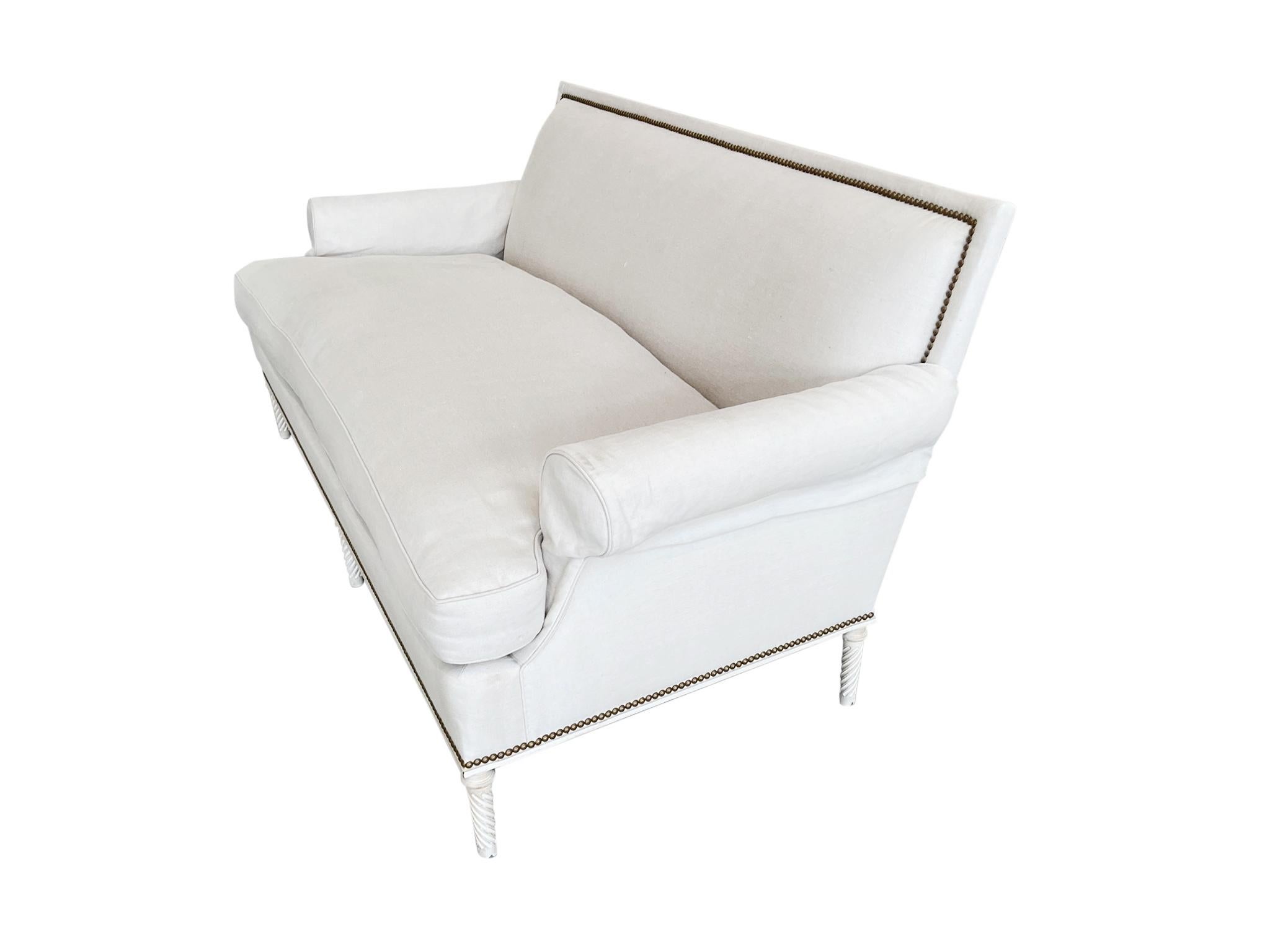 Fabriqué dans le style Louis XVI, ce canapé est recouvert d'un lin écru. Sur le plan structurel, son design est classique et simple, avec des lignes droites et des bras arrondis. Des montants métalliques délimitent le périmètre du cadre. Il y a 6