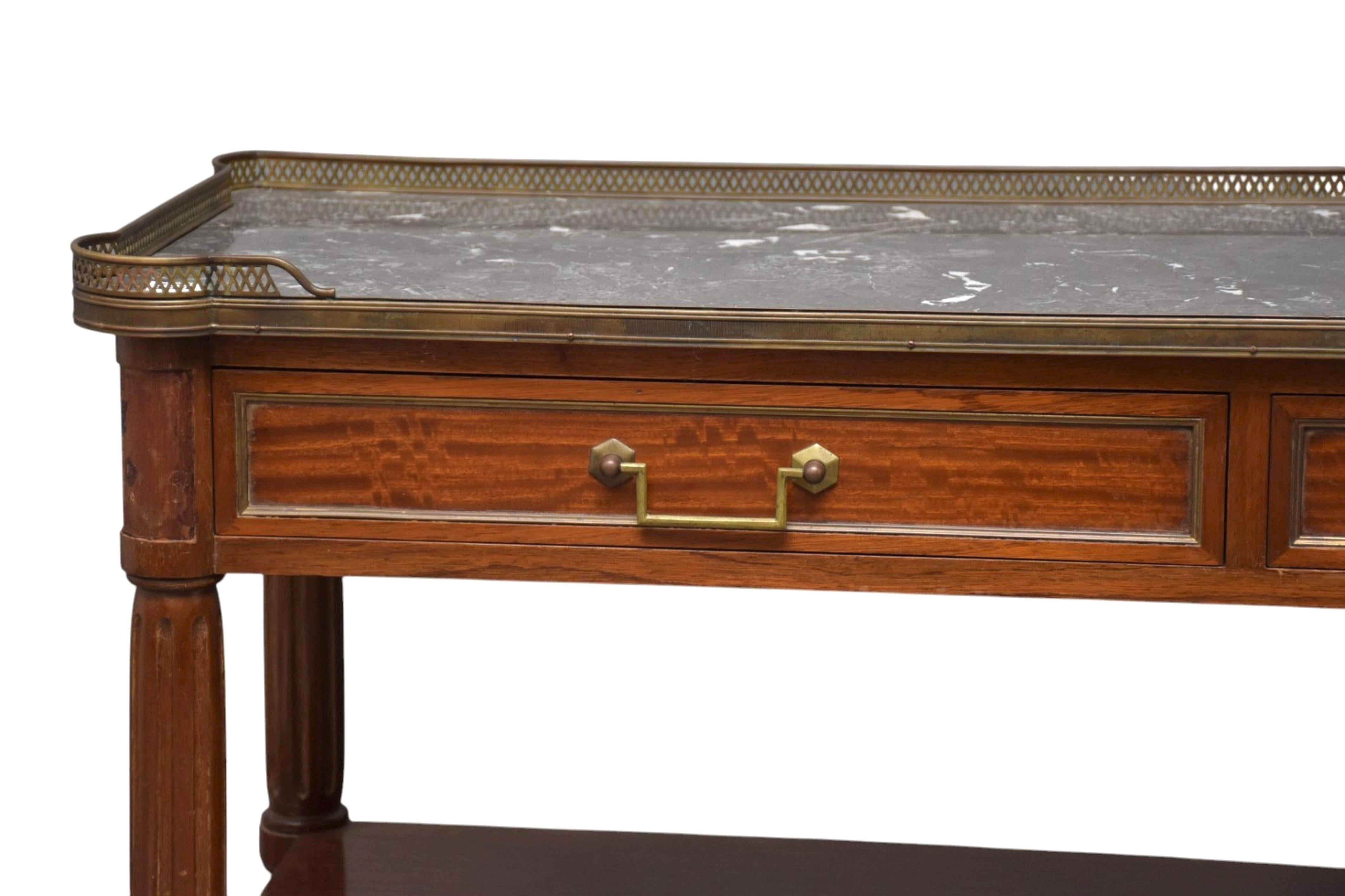 Début du 20e siècle, table console à dessert, buffet, serveur ou étagère en acajou de style Louis XVI. Le plateau en marbre est doté d'une galerie réticulée en laiton.  Sous le plateau en marbre se trouvent deux tiroirs côte à côte avec des poignées