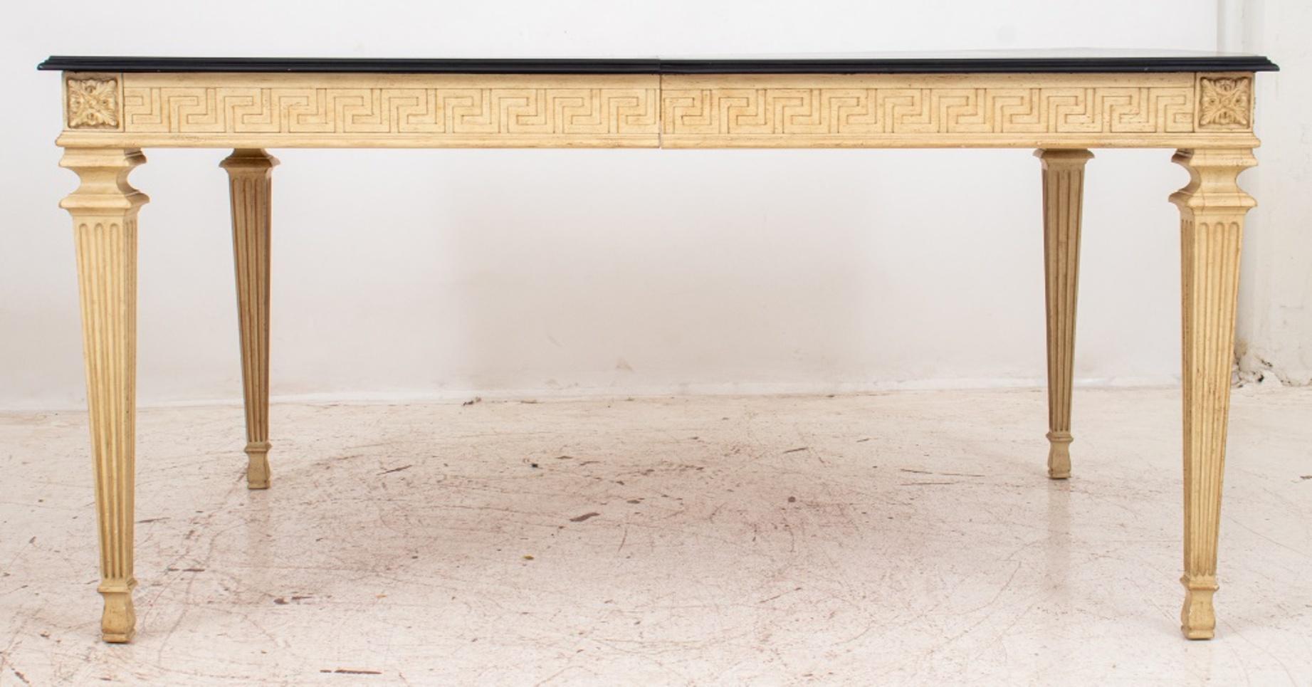 Table de salle à manger de style Louis XVI à rallonges peintes en blanc, le plateau rectangulaire façonné surmontant un tablier décoré d'un motif de méandre ou de clé grecque, avec des coins à tête de patera sur des pieds cannelés carrés effilés se