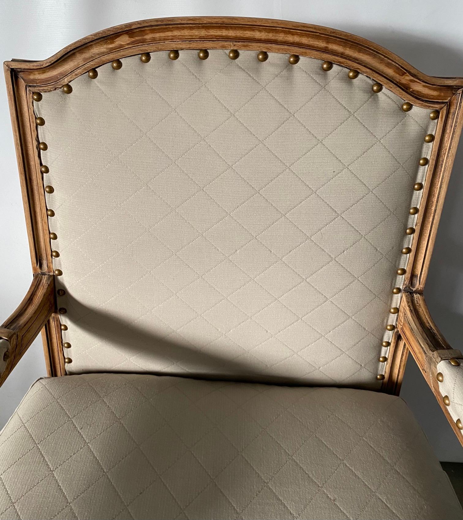 Elégant fauteuil français de style Louis XVI avec une structure en bois blanchi, un pied cannelé et des blocs cubiques décorés de fleurons, tapissé en tissu beige classique adapté. Convient aux chaises de salle à manger ou de bureau, aux chaises de
